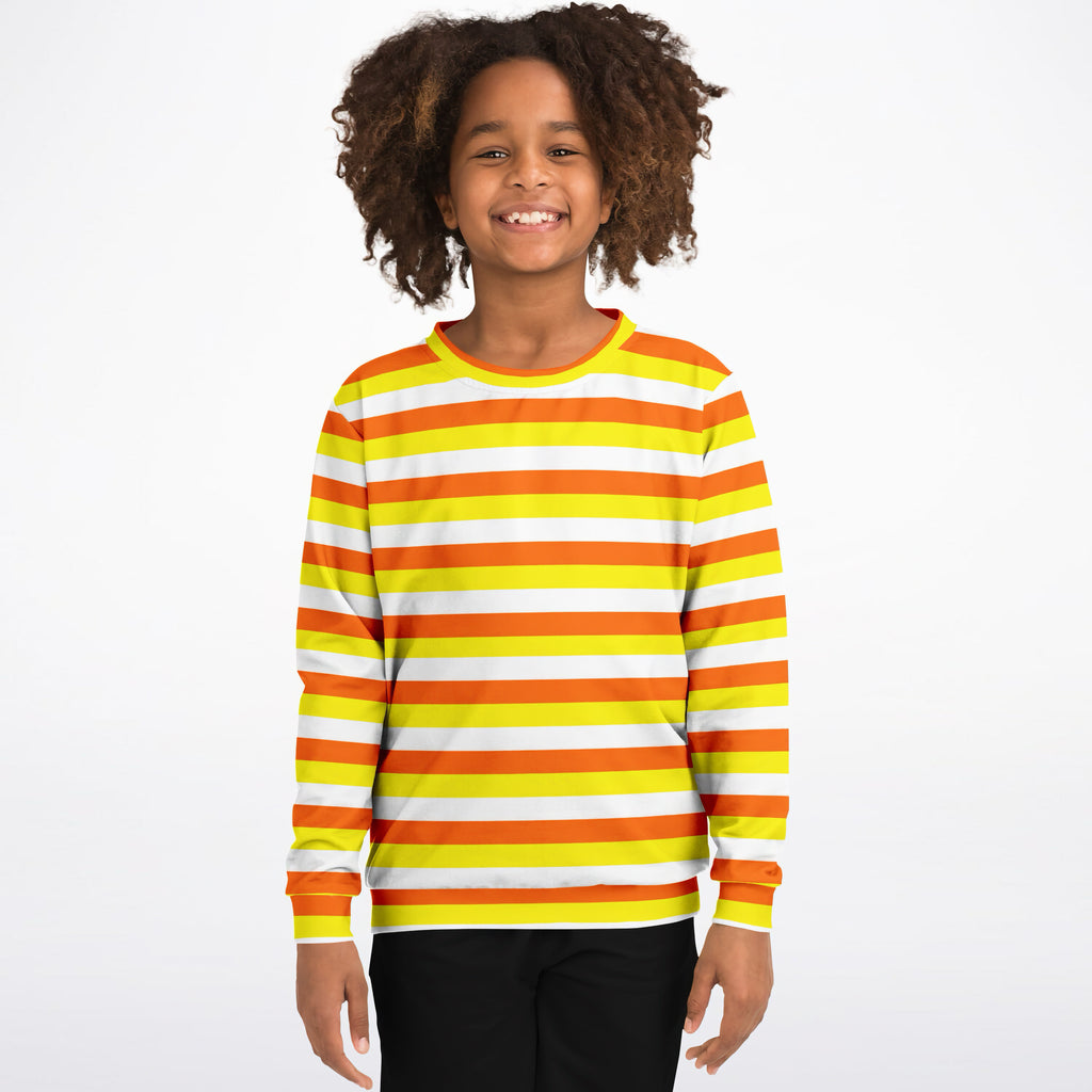 A child wearing a kids candy corn stripes halloween sweatshirt with orange yellow white stripes in cozy cotton fleece
