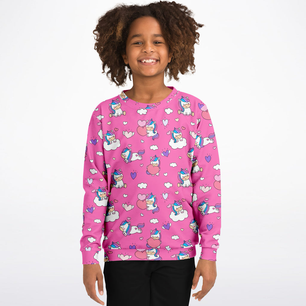 Girls pink unicorn hearts sweatshirt with playful cartoon pattern made of cozy cotton fleece or lightweight sports fabric