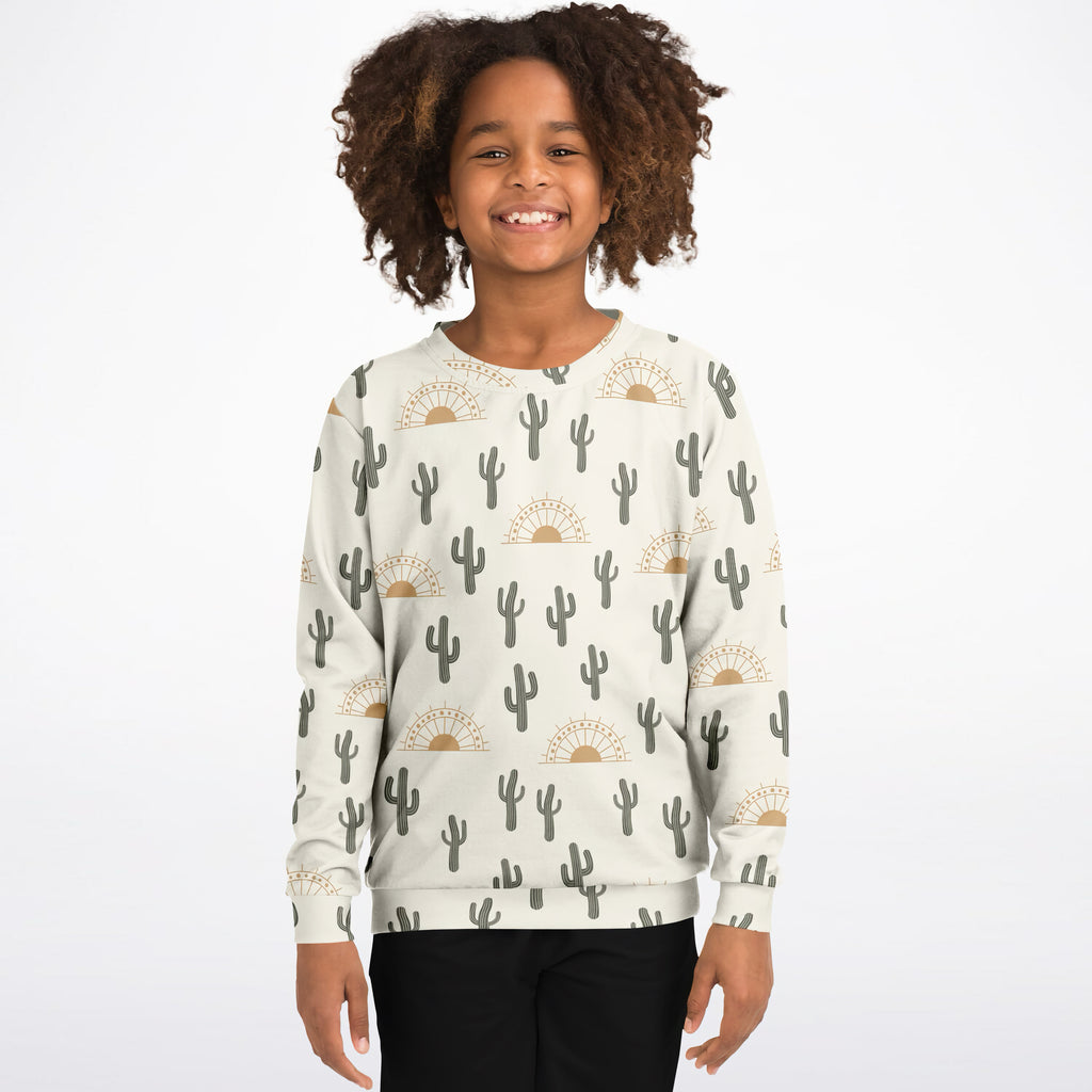A child wearing a cream kids zebra print sweatshirt with gray cacti and golden sun motifs in cozy cotton fleece