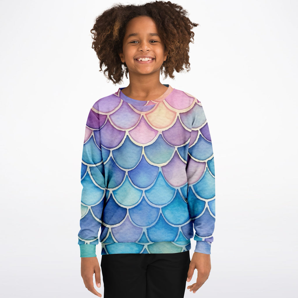 A child wearing a girls colorful mermaid scales sweatshirt in pastel purple blue and pink cozy cotton fleece fabric