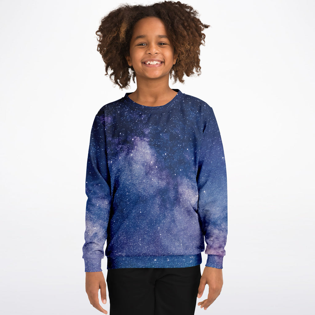 A child wearing a kids realistic galaxy sweatshirt with deep blue and purple cosmic print in cozy cotton fleece