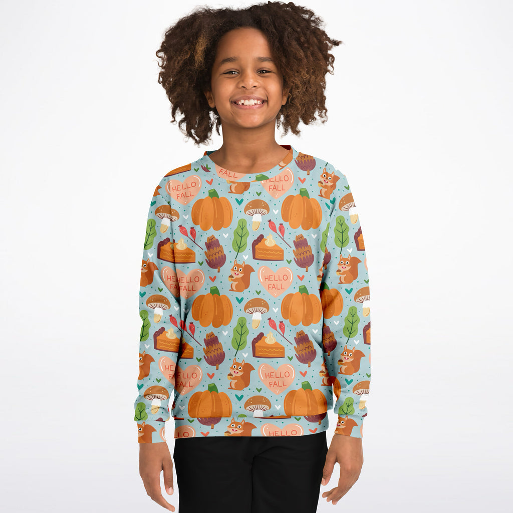 A child wearing a light blue kids hello fall autumn themed sweatshirt with pumpkins squirrels and pie slices in cotton fleece
