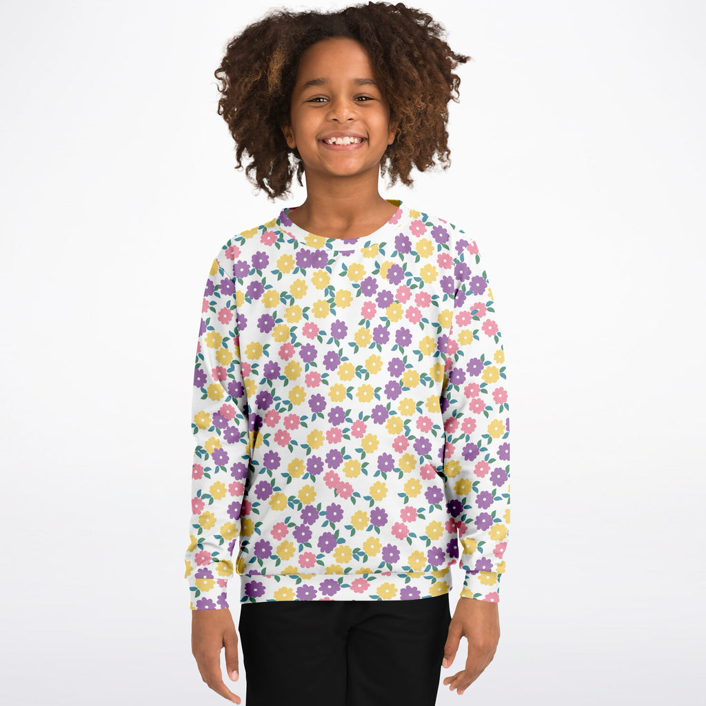 A child wearing a white girls colorful floral sweatshirt with cheerful purple pink and yellow flowers in cozy cotton fleece