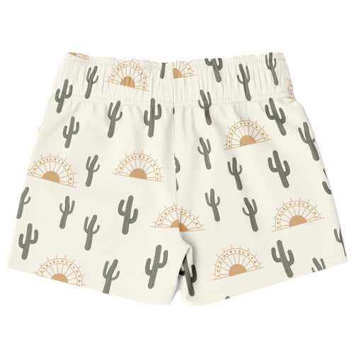 Cream-colored boys quick drying swim trunks with gray cactus and tan sunburst patterns for desert sunrise
