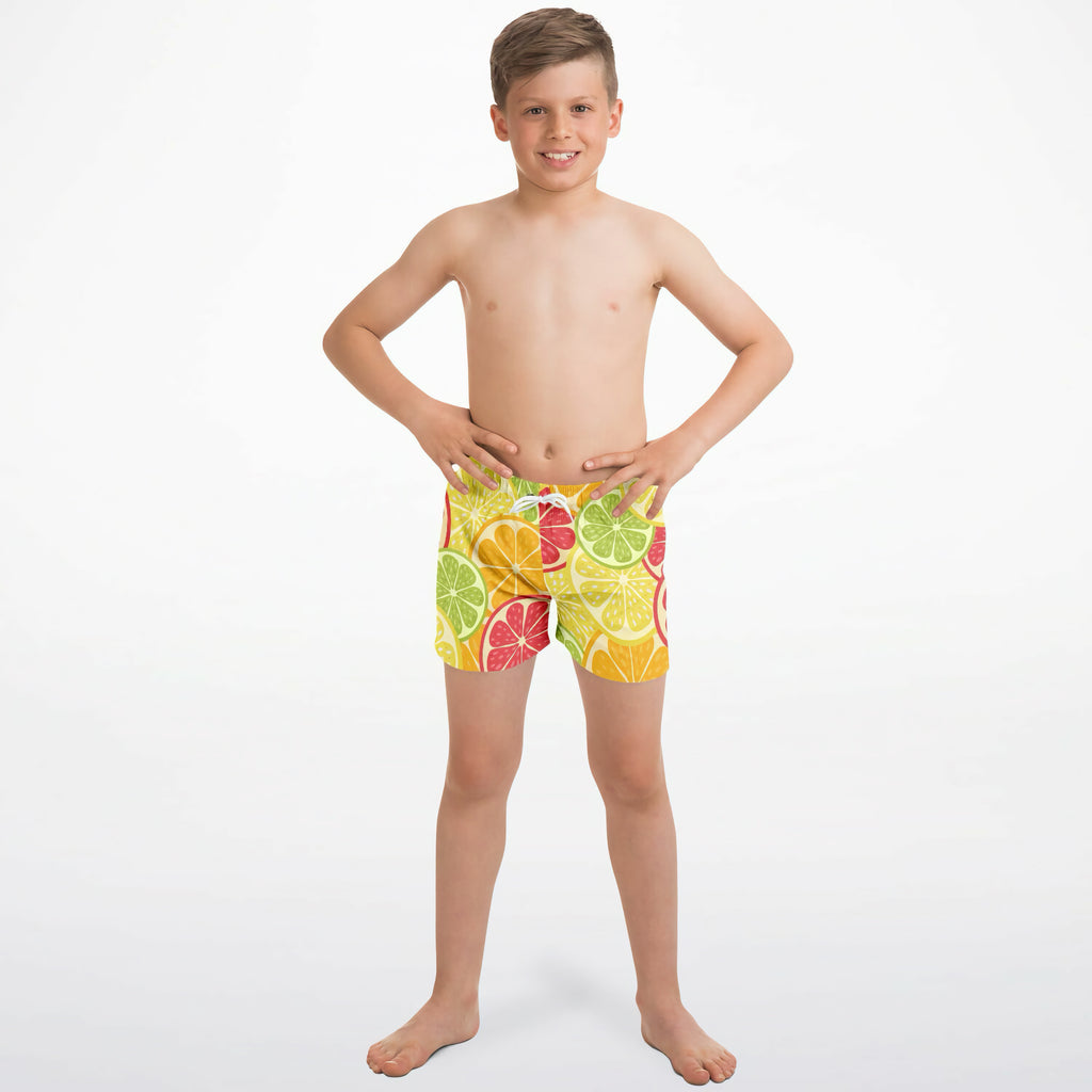 Boys citrus fruit quick drying swim trunks with a vibrant pattern of sliced green yellow and red citrus fruits