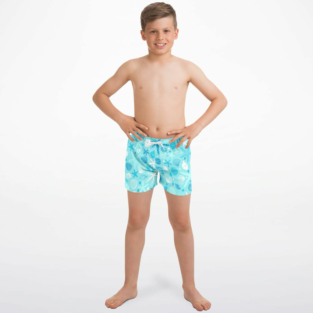 Light blue quick drying boys swim trunks with a playful white seashell starfish and seaweed pattern