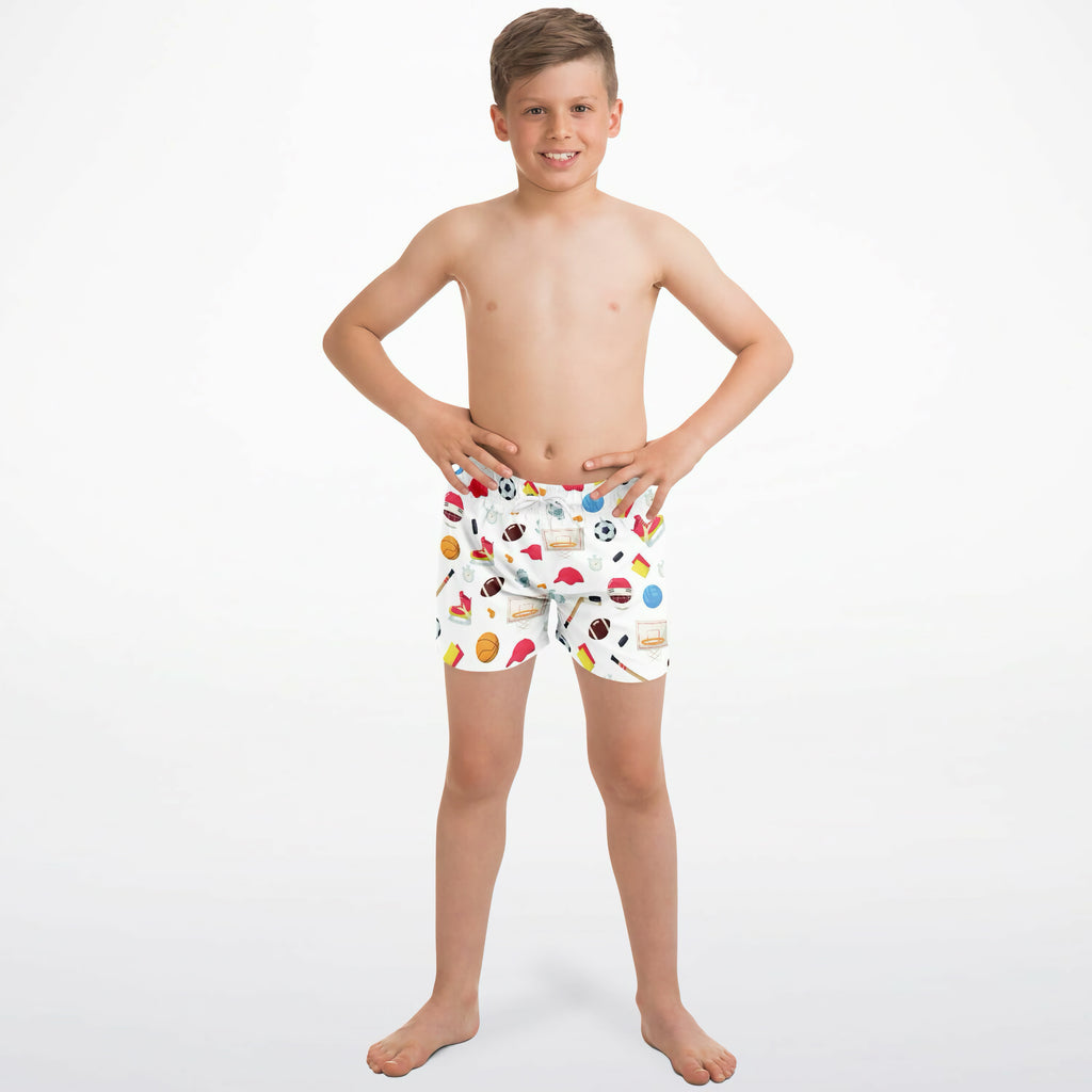 White boys sports-themed quick drying swim trunks with colorful soccer balls basketballs and flags pattern
