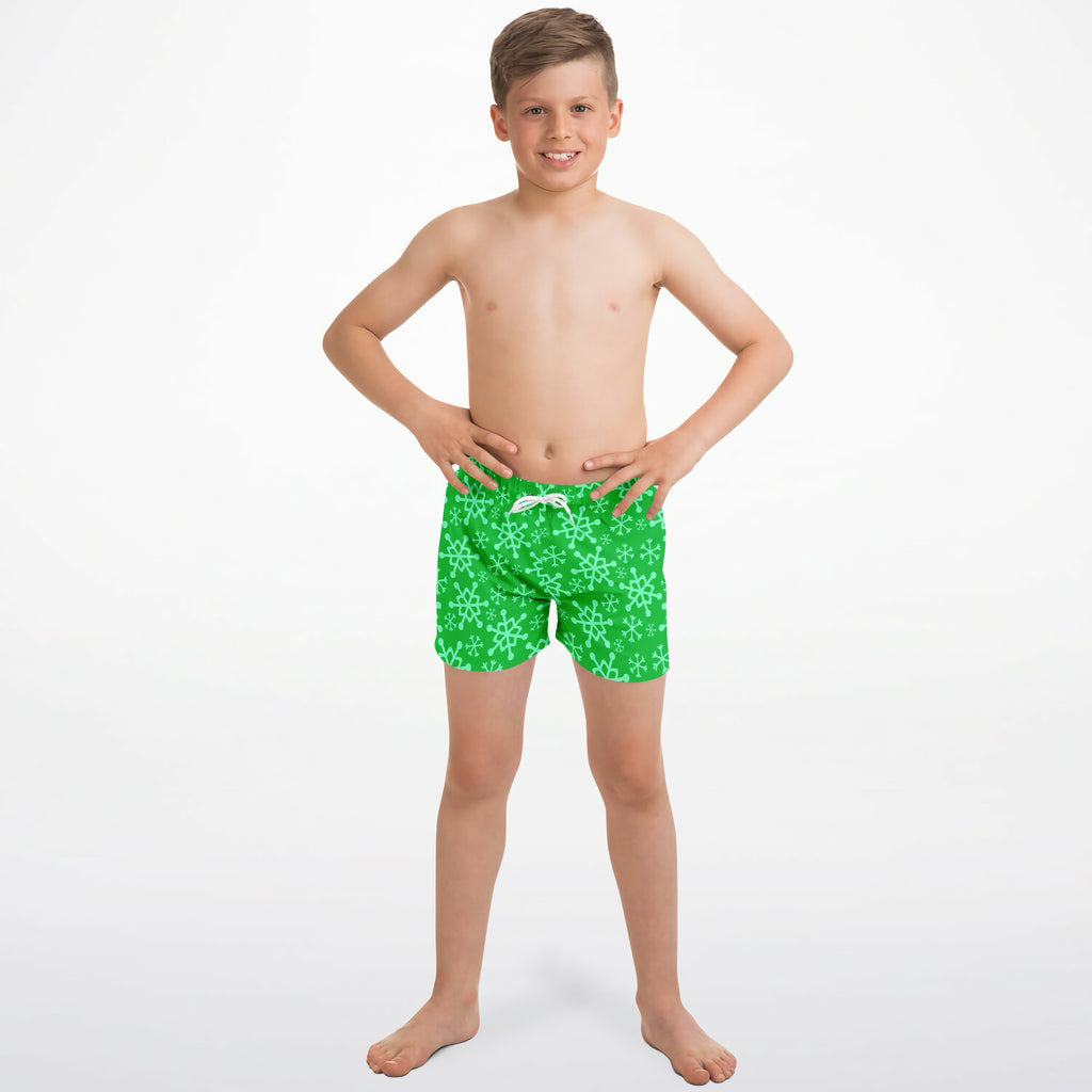 Boys bright green quick drying swim trunks with a repeating light snowflake pattern for Christmas use