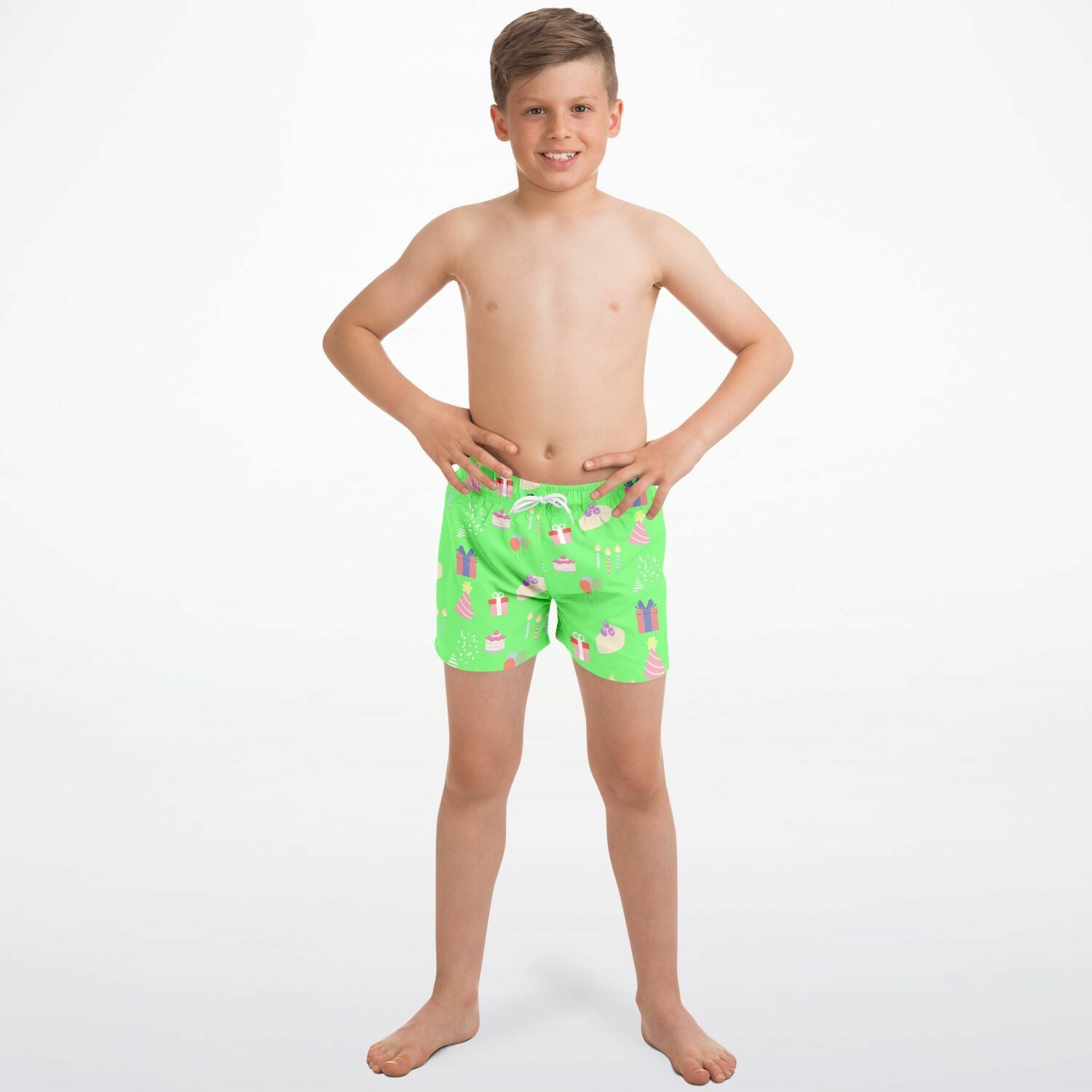 Child wearing green swim shorts with a birthday pattern on a white background