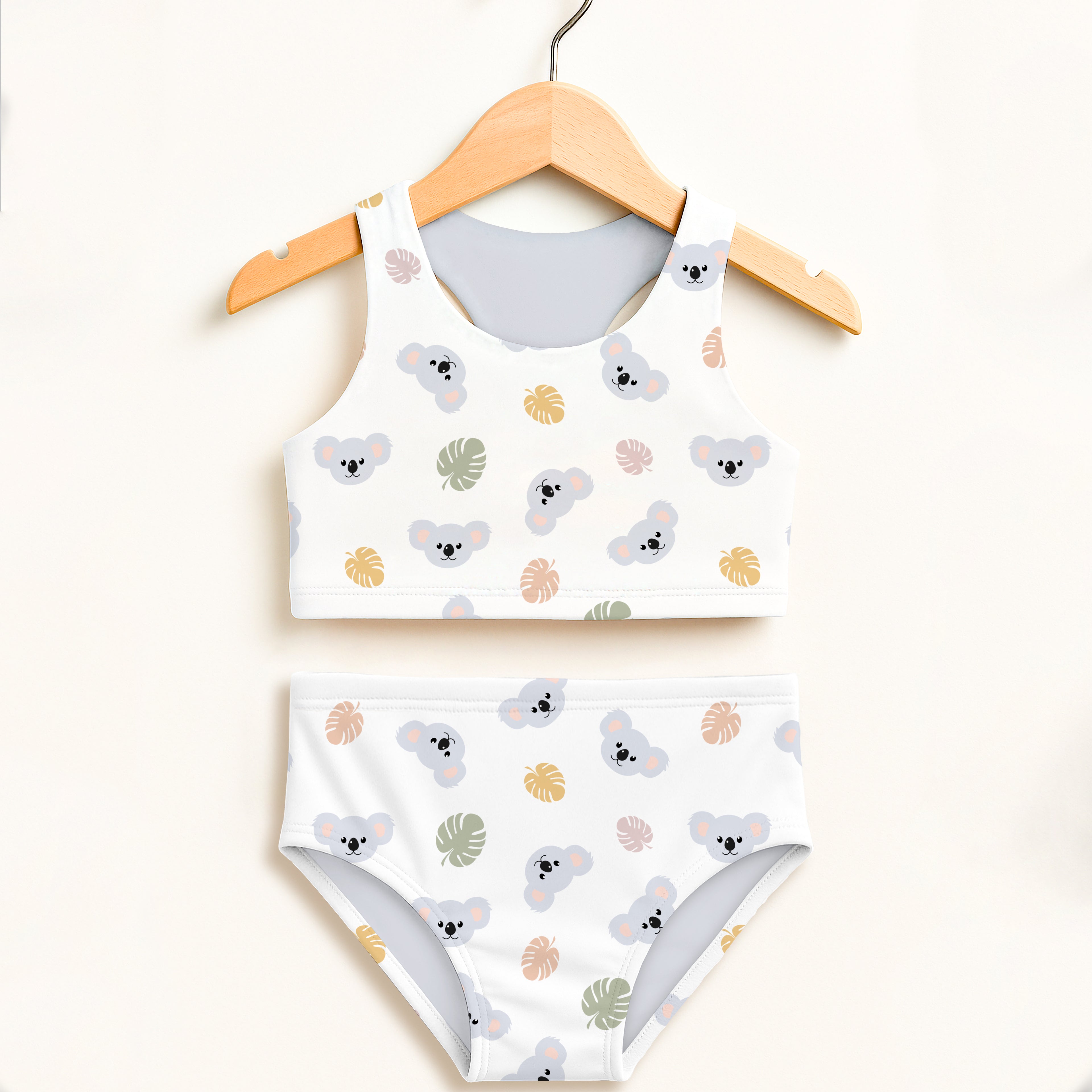 Girls koala two piece swimsuit in white with gray koalas and muted gold tropical leaves featuring upf 50 plus fabric