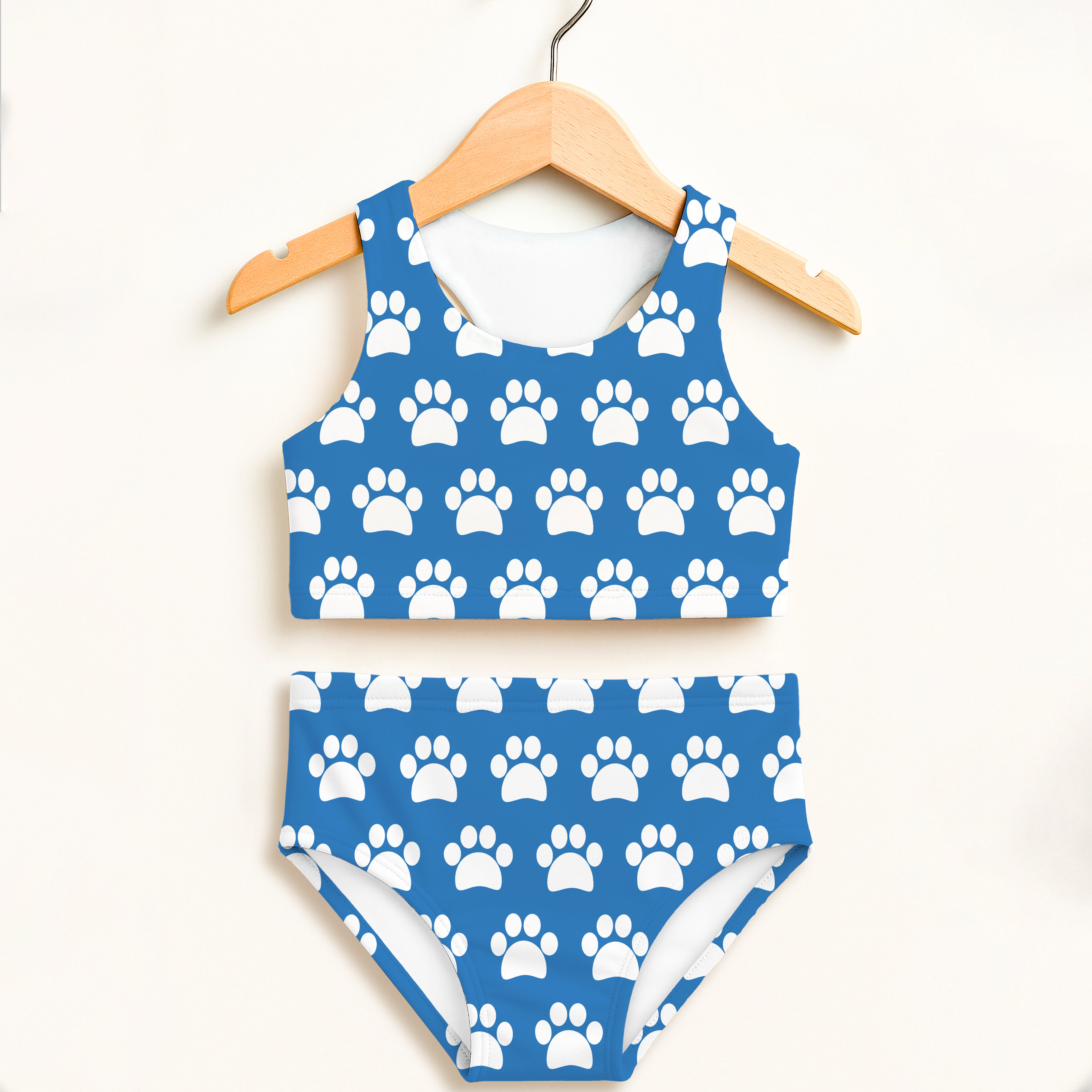 Girls blue two-piece swimsuit with white paw print pattern featuring halter top and high-waisted double layered upf 50+ fabric