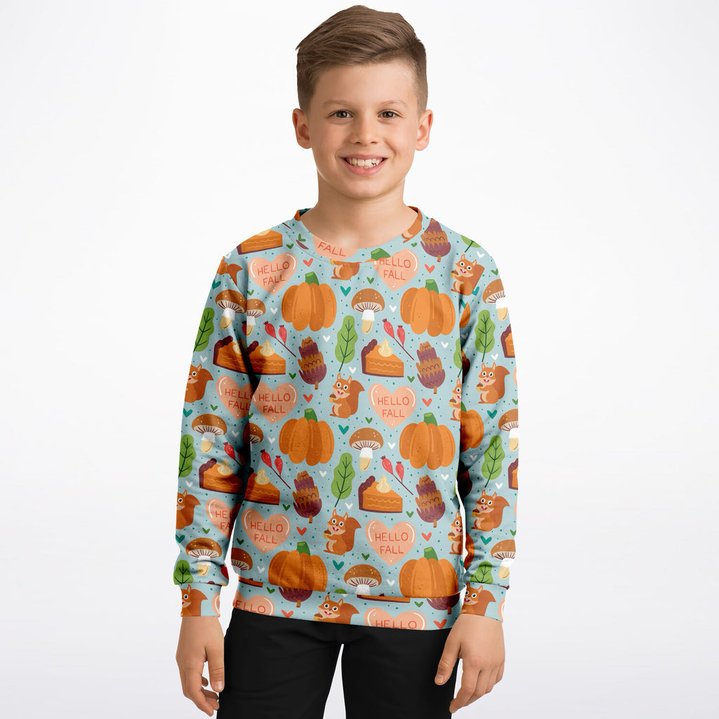 A boy wearing a light blue kids hello fall autumn sweatshirt with pumpkins squirrels in cozy cotton fleece