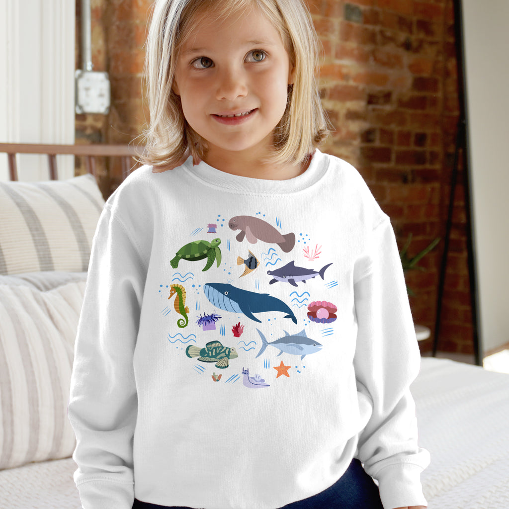 White long-sleeved kids sweatshirt with colorful cartoon ocean animals featuring turtles whales sharks and more