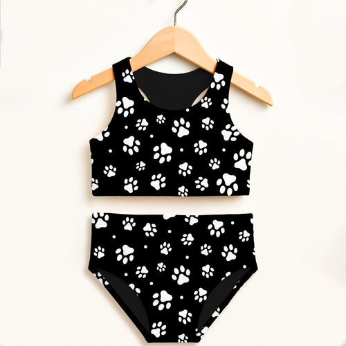 Girls black and white paw print two-piece swimsuit hanging on wooden hanger with double layered upf 50+ high waisted design