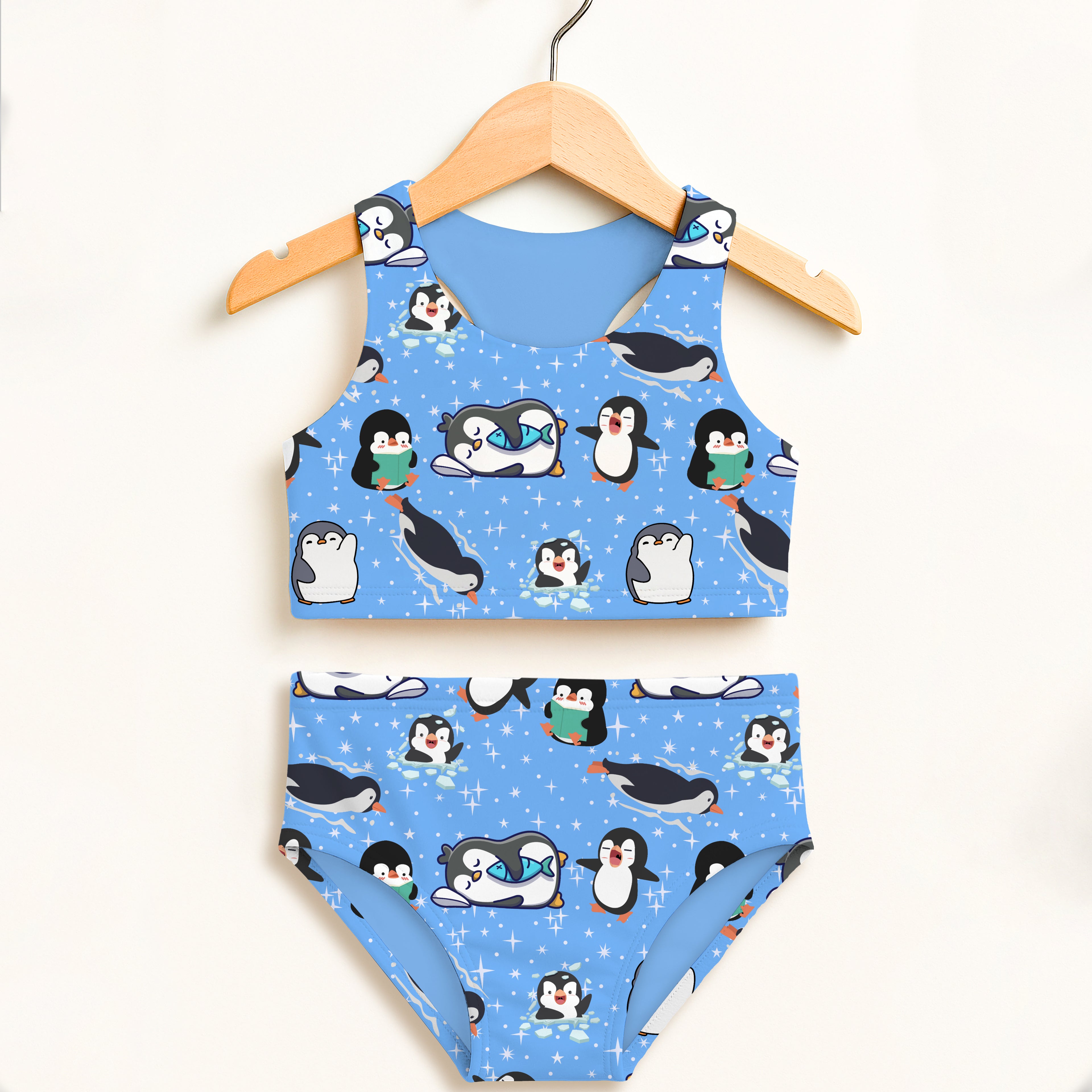Girls penguin two piece swimsuit with cartoon black and white penguins on light blue double layered upf 50 high waisted fabric
