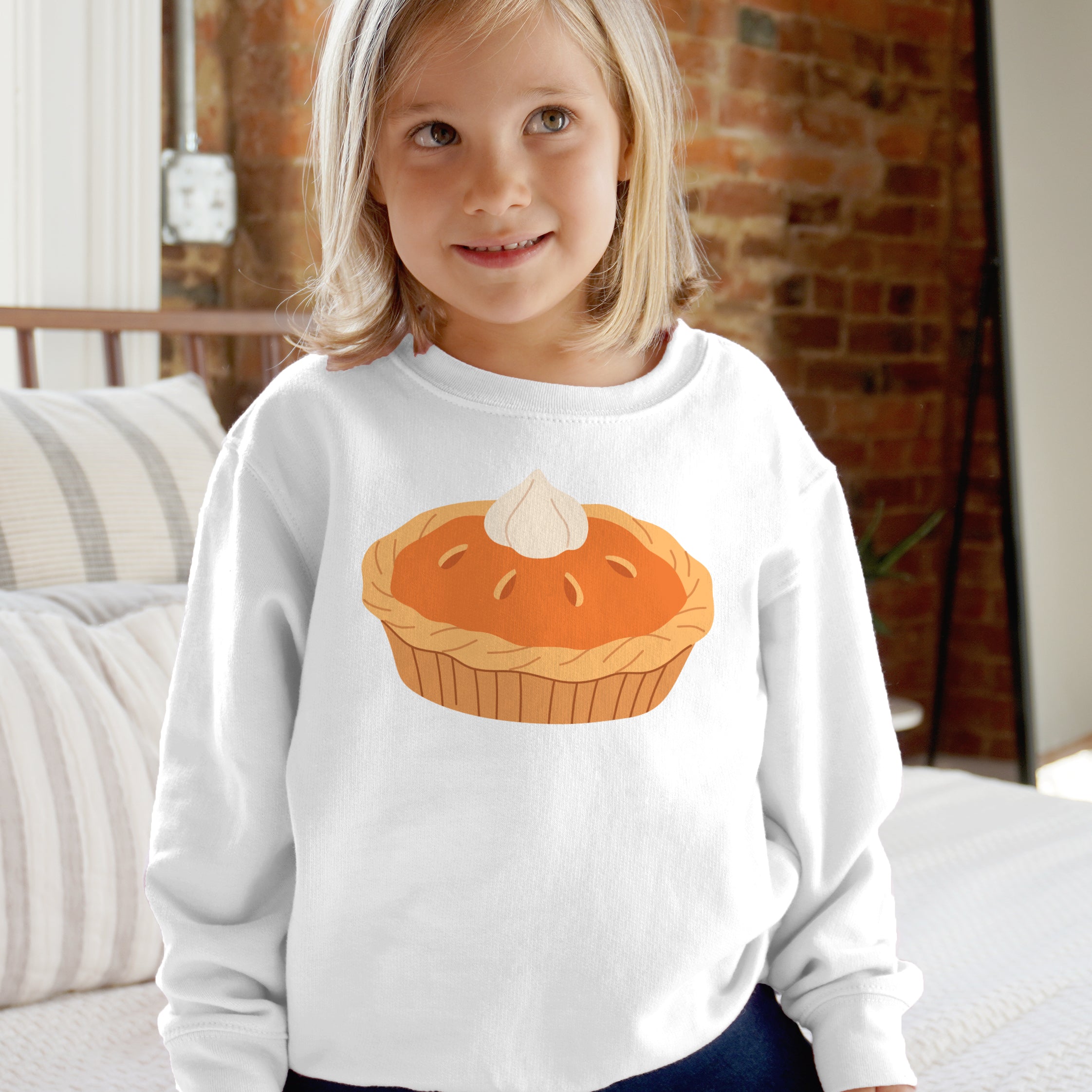 White long-sleeved kids sweatshirt featuring a cartoon orange pumpkin pie with white dollop for Thanksgiving fall