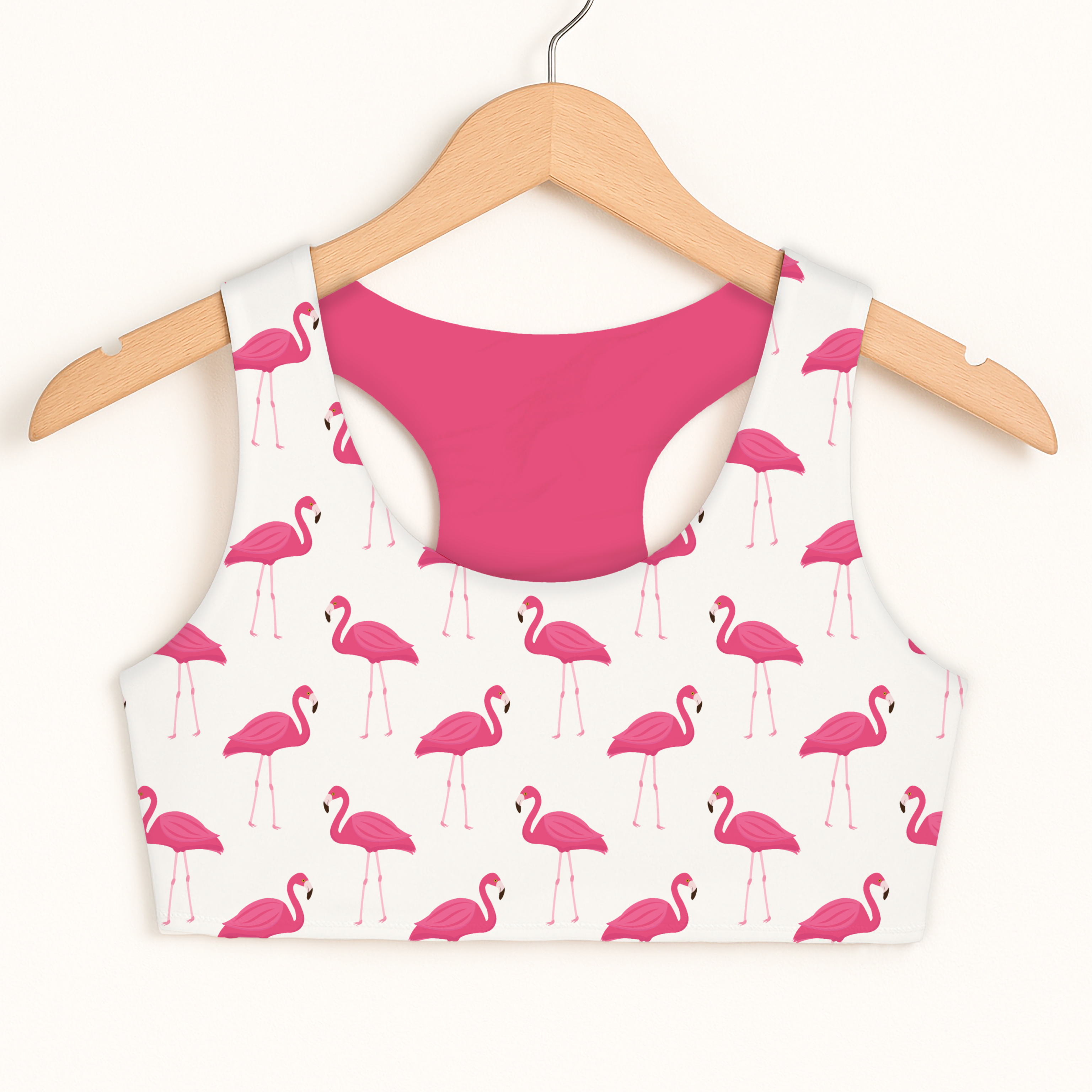 Girls pink flamingo sports bra with vibrant print quick drying double layered comfort displayed on wooden hanger