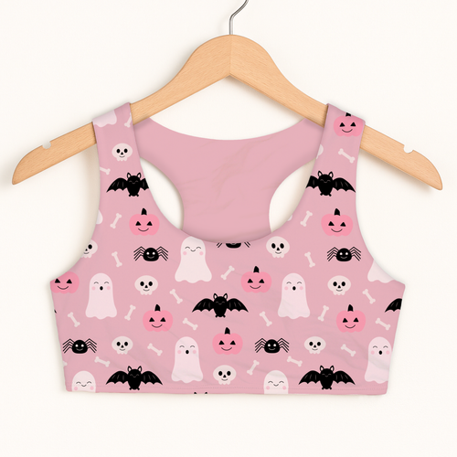 Pink halloween sports bra with black bats white ghosts and smiling pumpkins on soft quick drying fabric