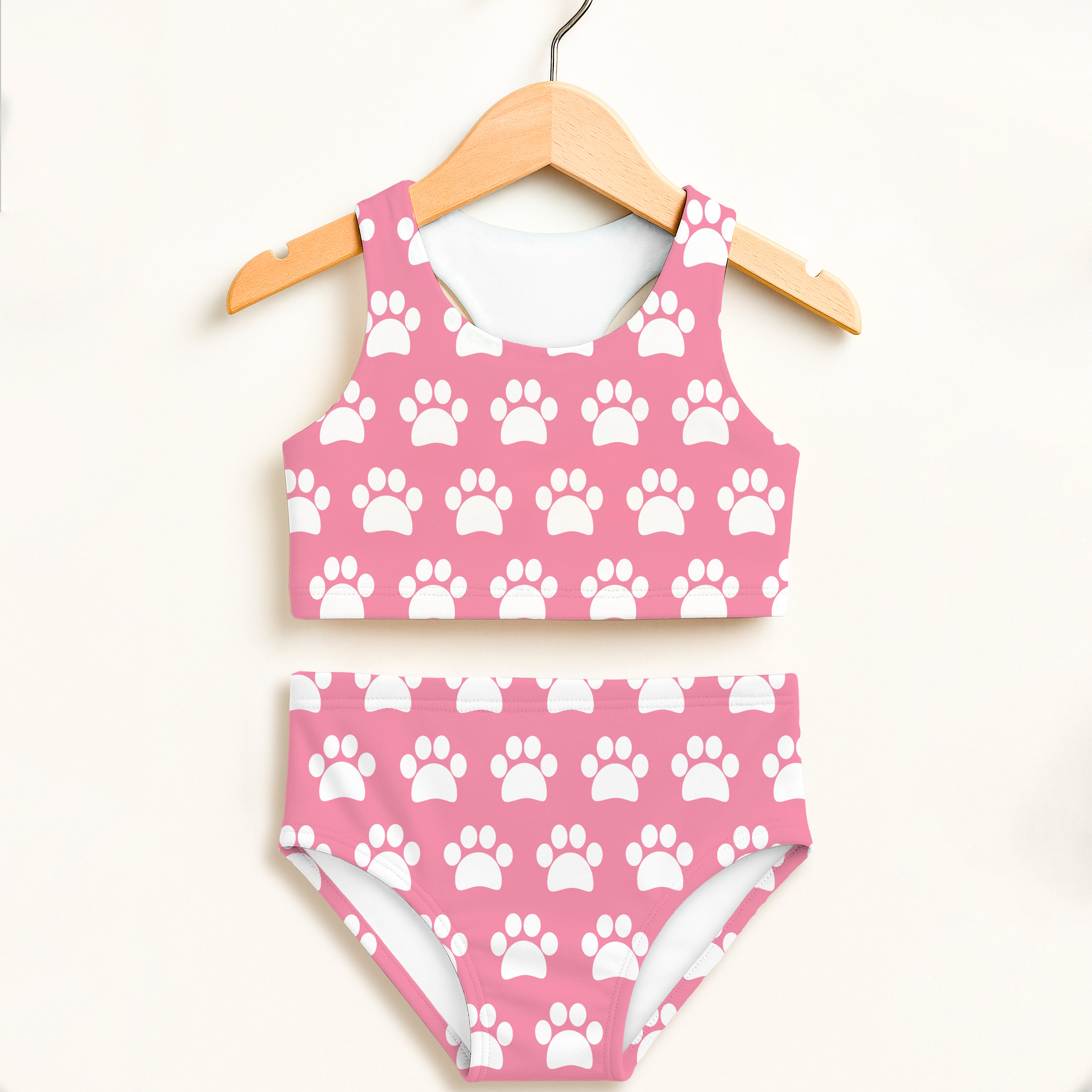 Girls pink two piece swimsuit with white paw prints featuring a halter top and high waisted comfort design
