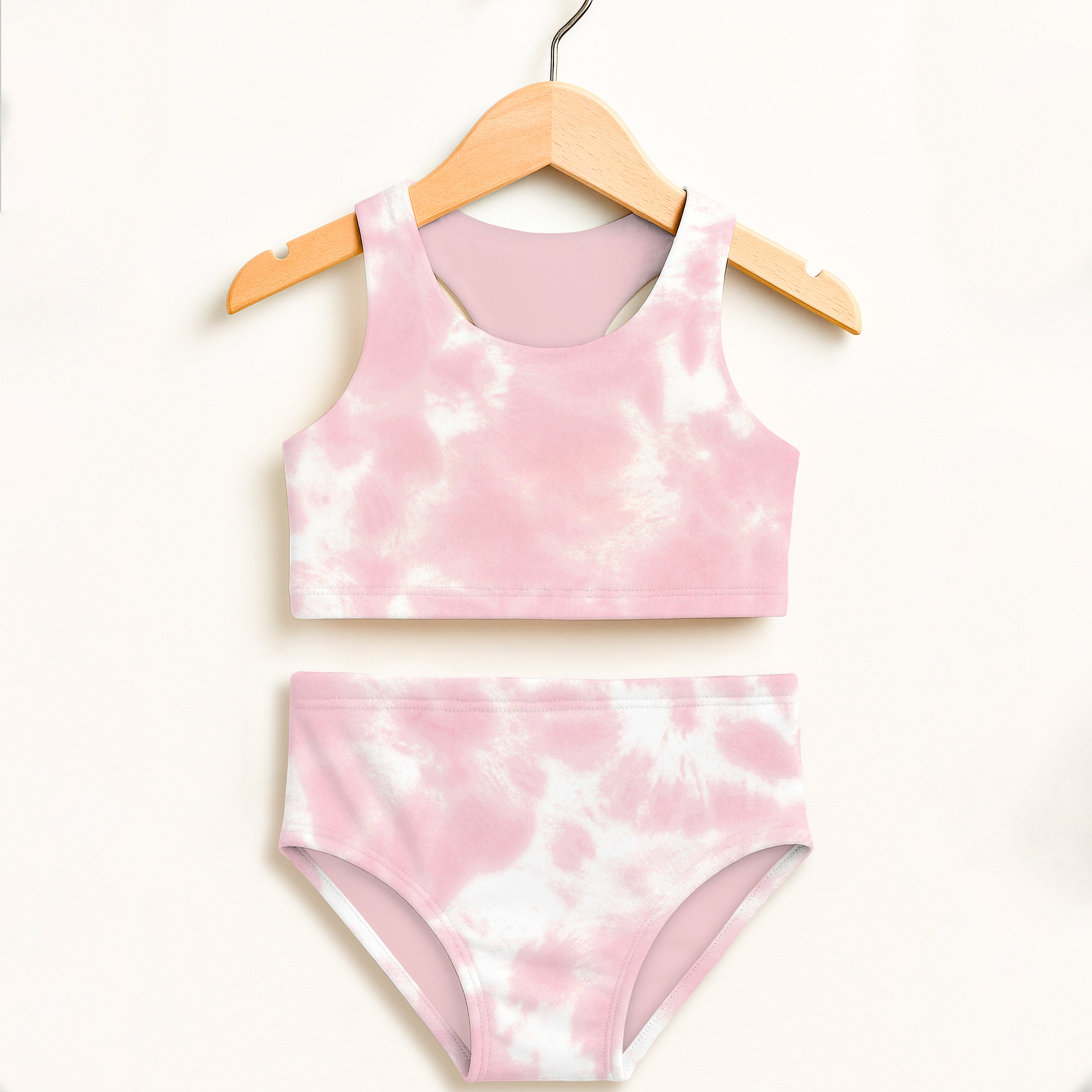 Girls pink and white tie dye two piece swimsuit hanging on wooden hanger with double layered upf 50 plus fabric