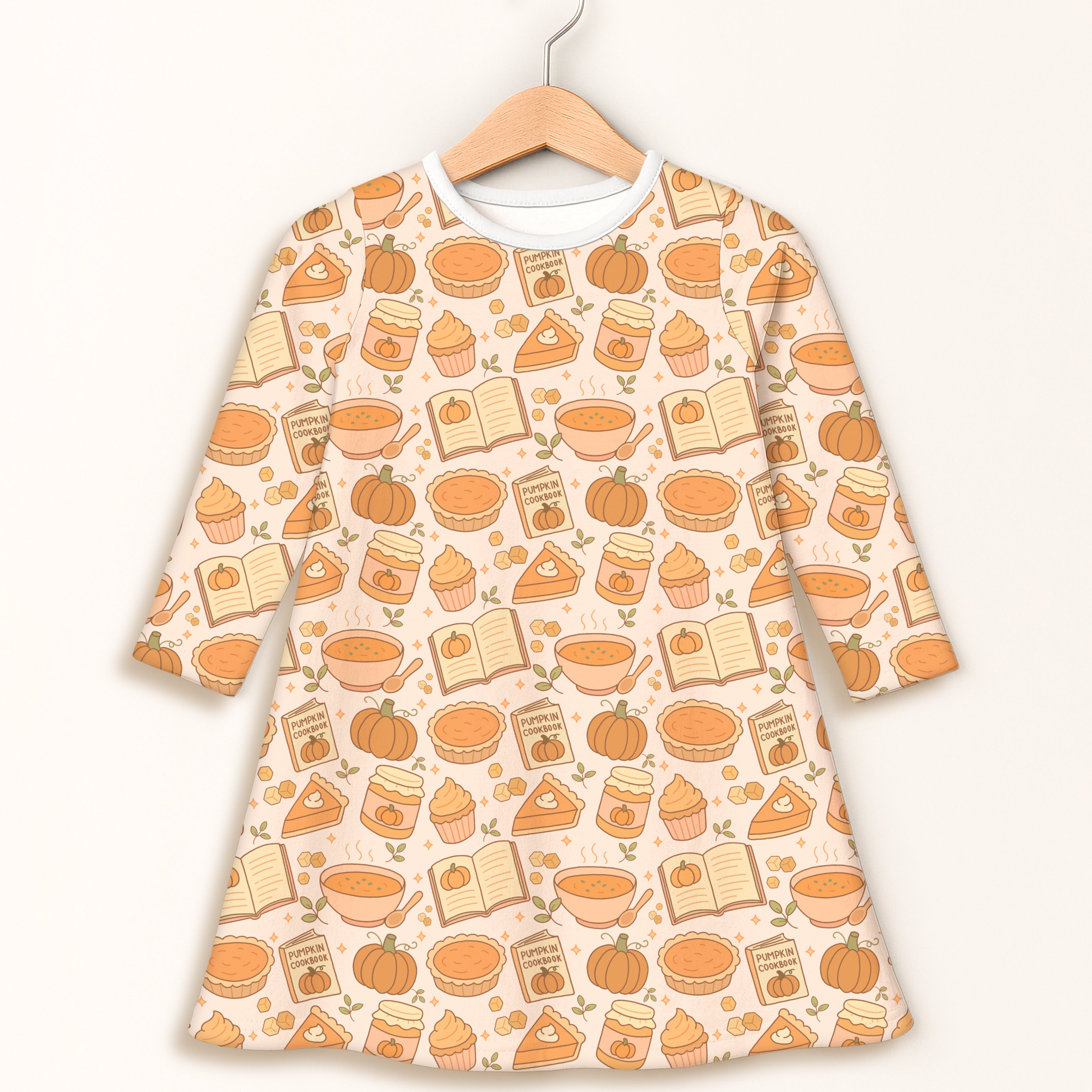 Girls pumpkin pie themed long sleeve a-line dress in soft cream with autumn illustrations of pumpkins pies cupcakes and cookbooks