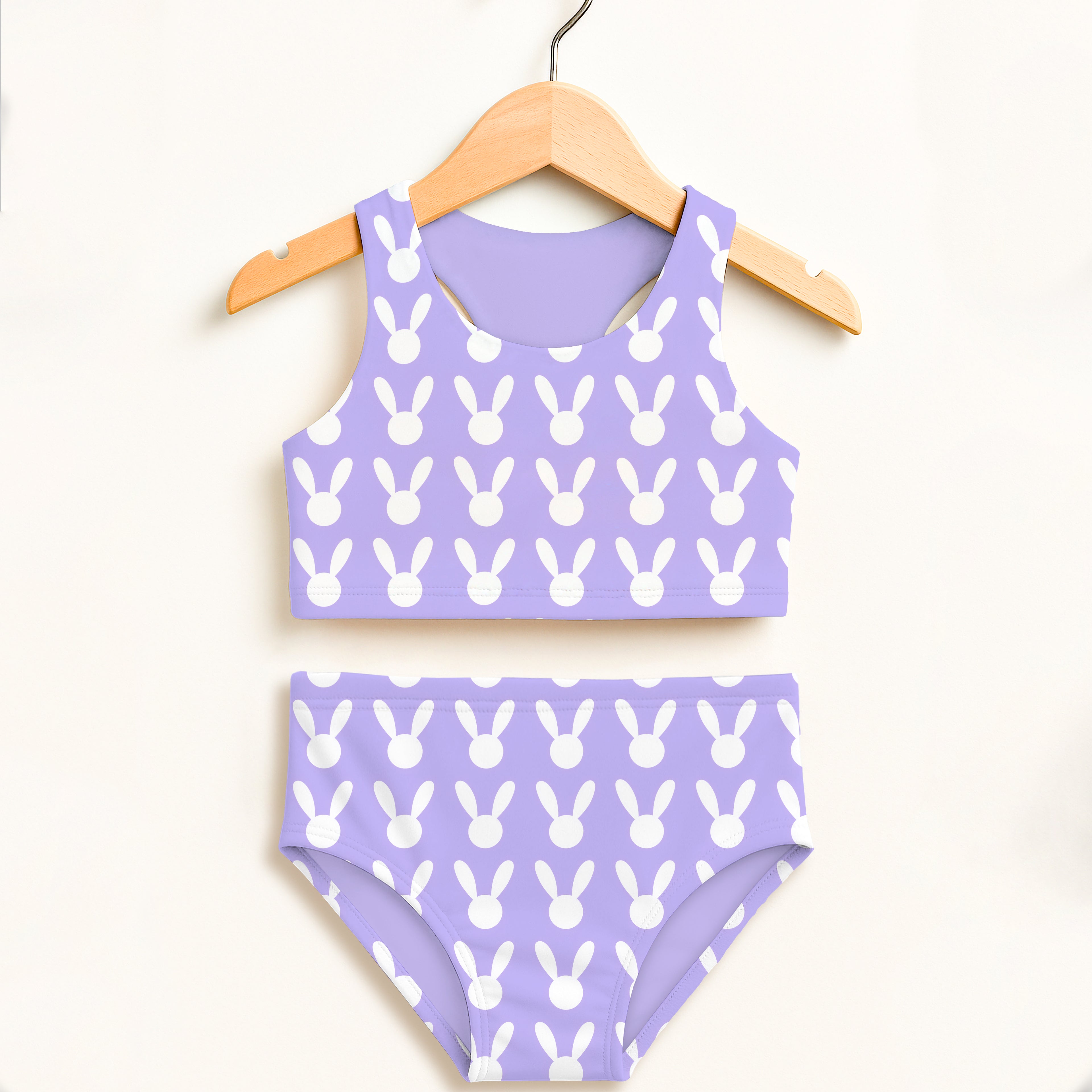 Girls lavender bunny two piece swimsuit hanging on wooden hanger with double layered upf 50 plus fabric