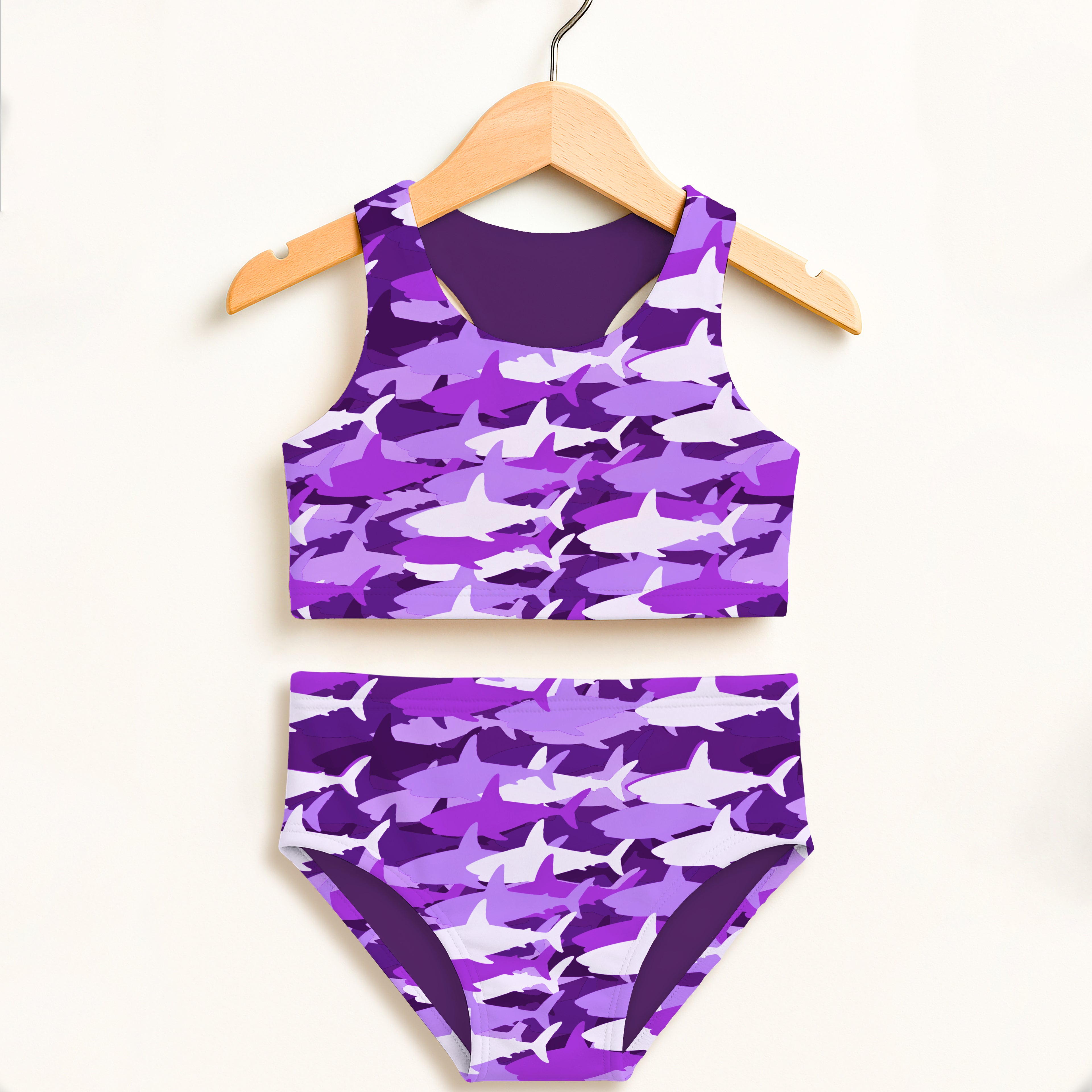 Girls purple and white shark camouflage two-piece swimsuit with double layered upf 50 high waisted comfort hanging on wooden hanger