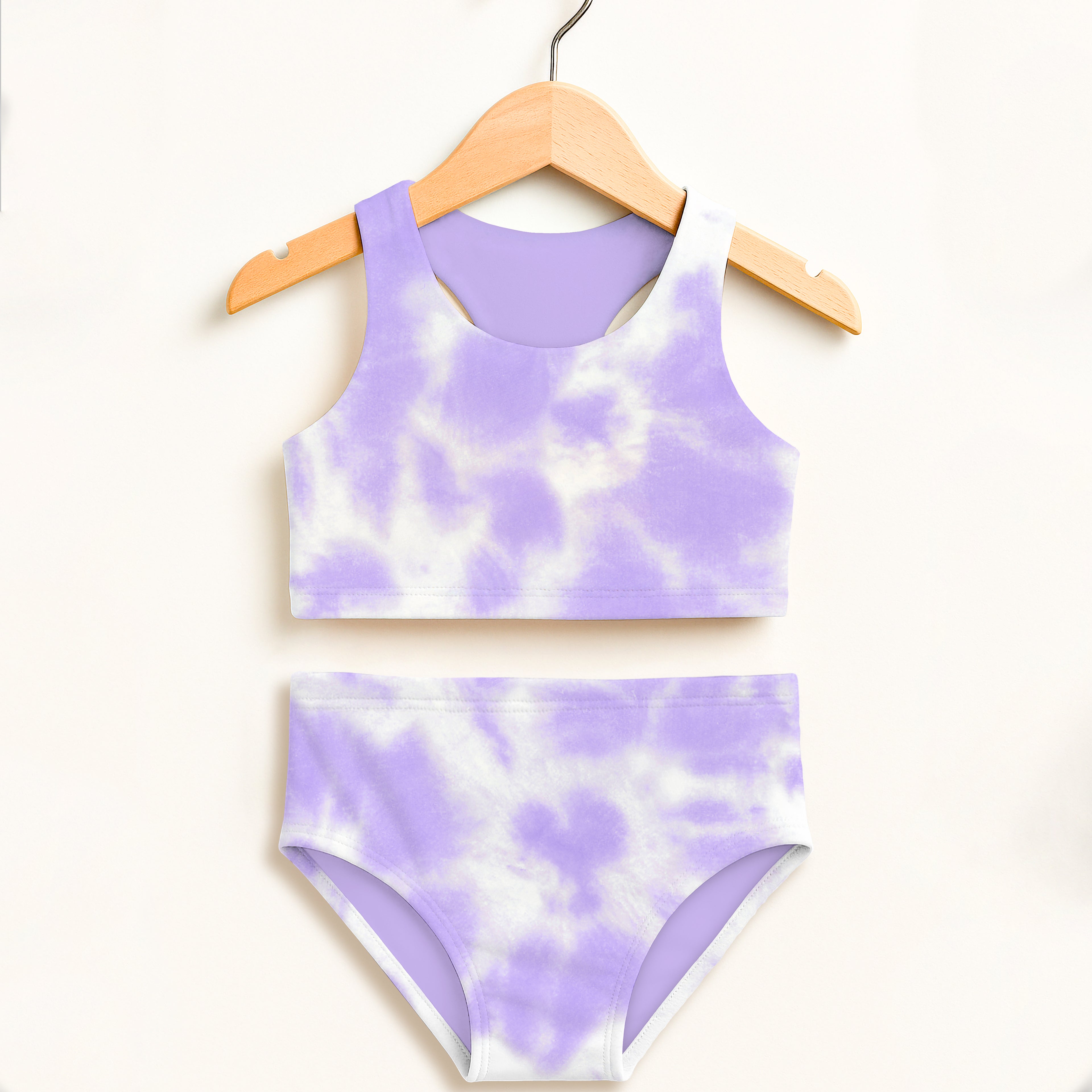 Girls purple and white tie dye two piece swimsuit hanging on wooden hanger with double layered UPF 50 plus fabric