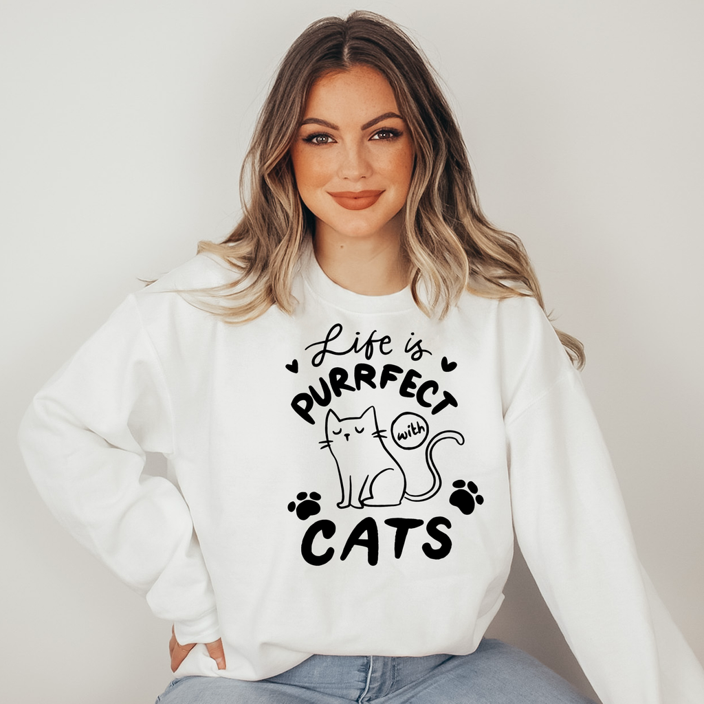 Woman wearing a white sweatshirt with a cat-themed design and text.
