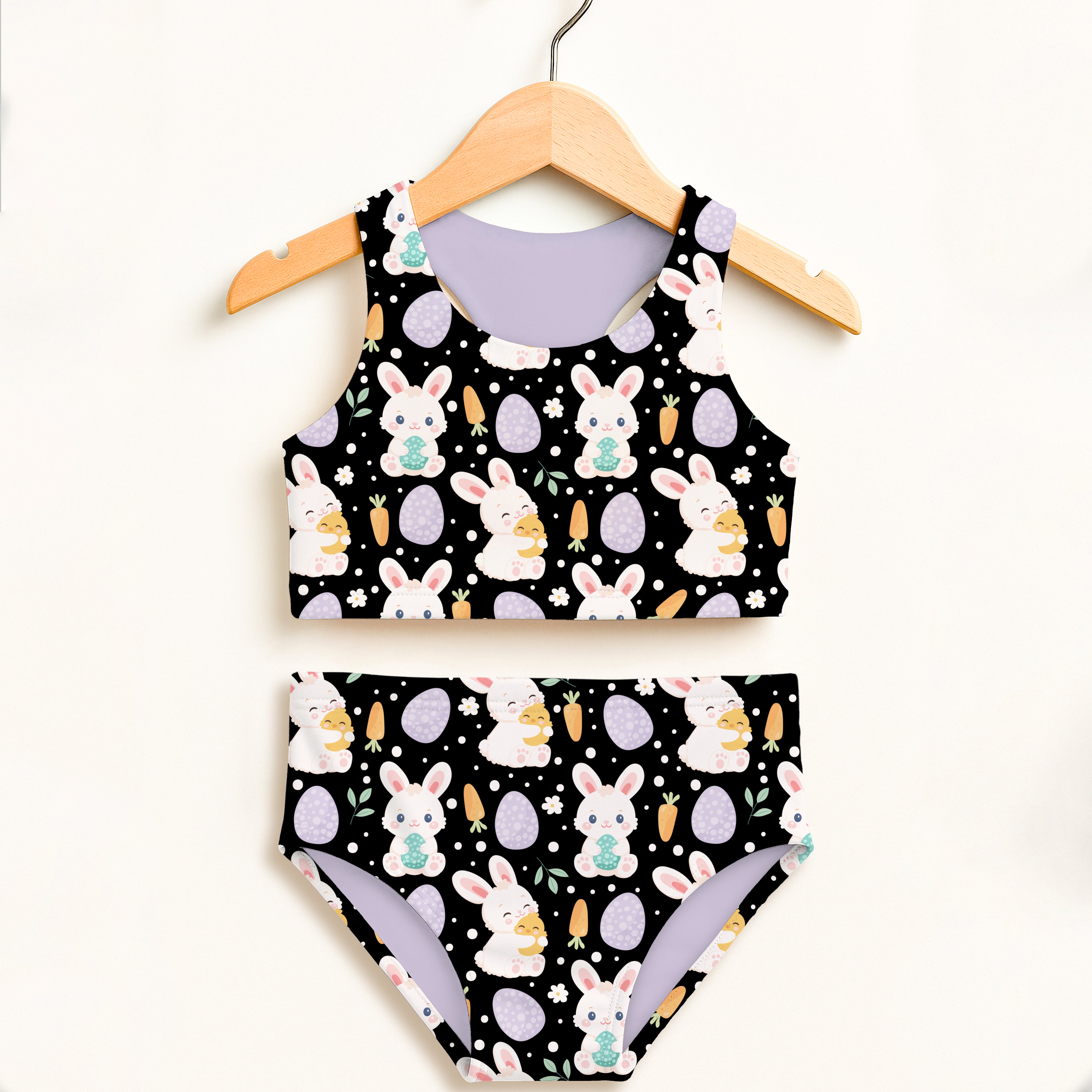 Girls black Easter bunny two piece swimsuit with egg-themed design and lavender double layered UPF 50+ high waisted lining