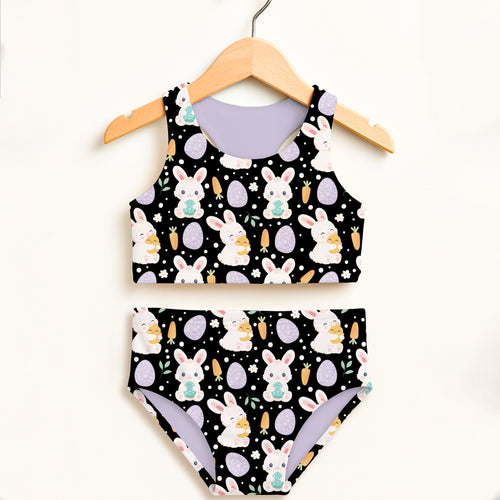Girls black Easter bunny two piece swimsuit with egg-themed design and lavender double layered UPF 50+ high waisted lining
