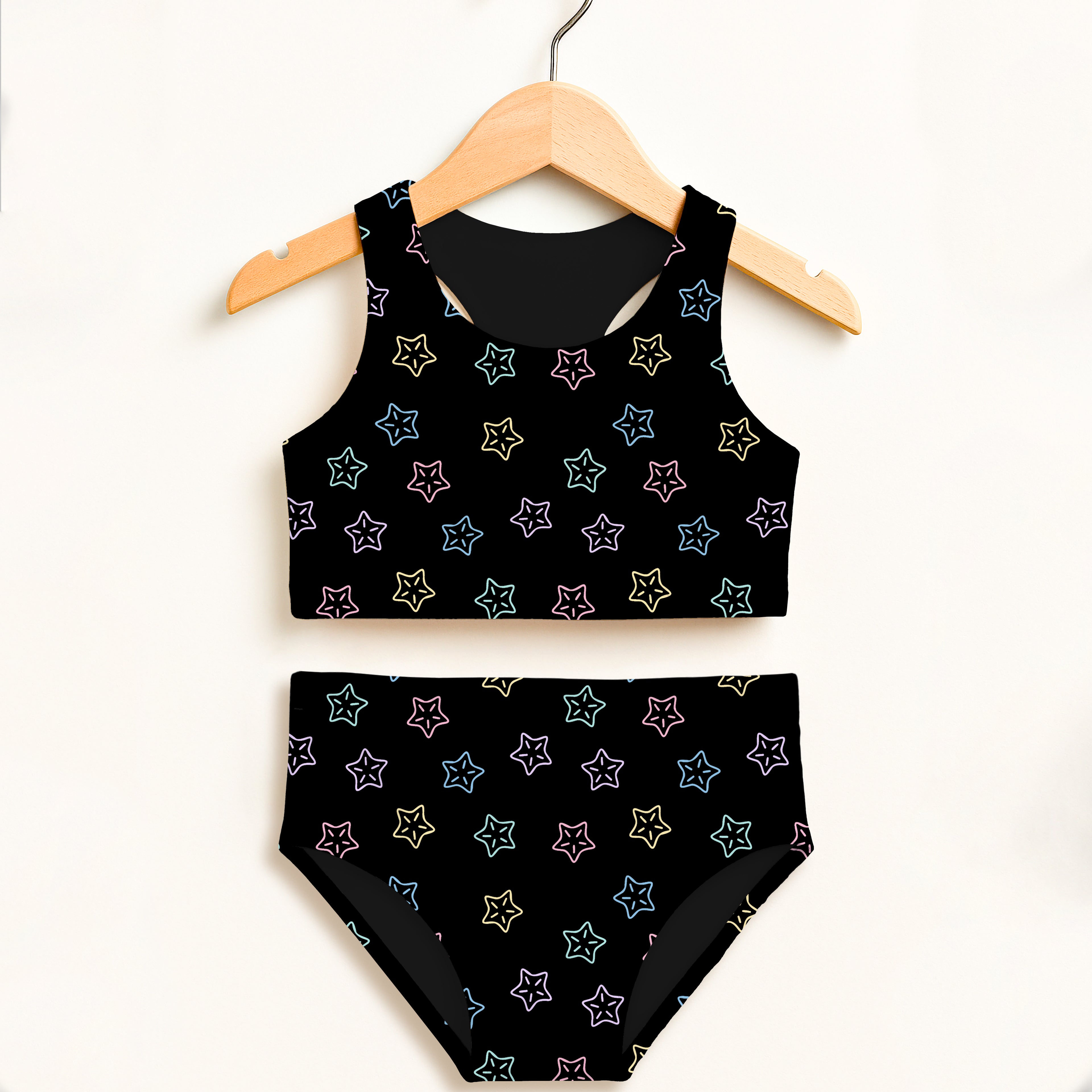 Girls rainbow starfish polka dot black star patterned two piece swimsuit with white outlined stars and upf 50+ fabric