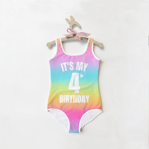 A girls custom bright rainbow one-piece swimsuit with white trim and it’s my 4th birthday bold white text