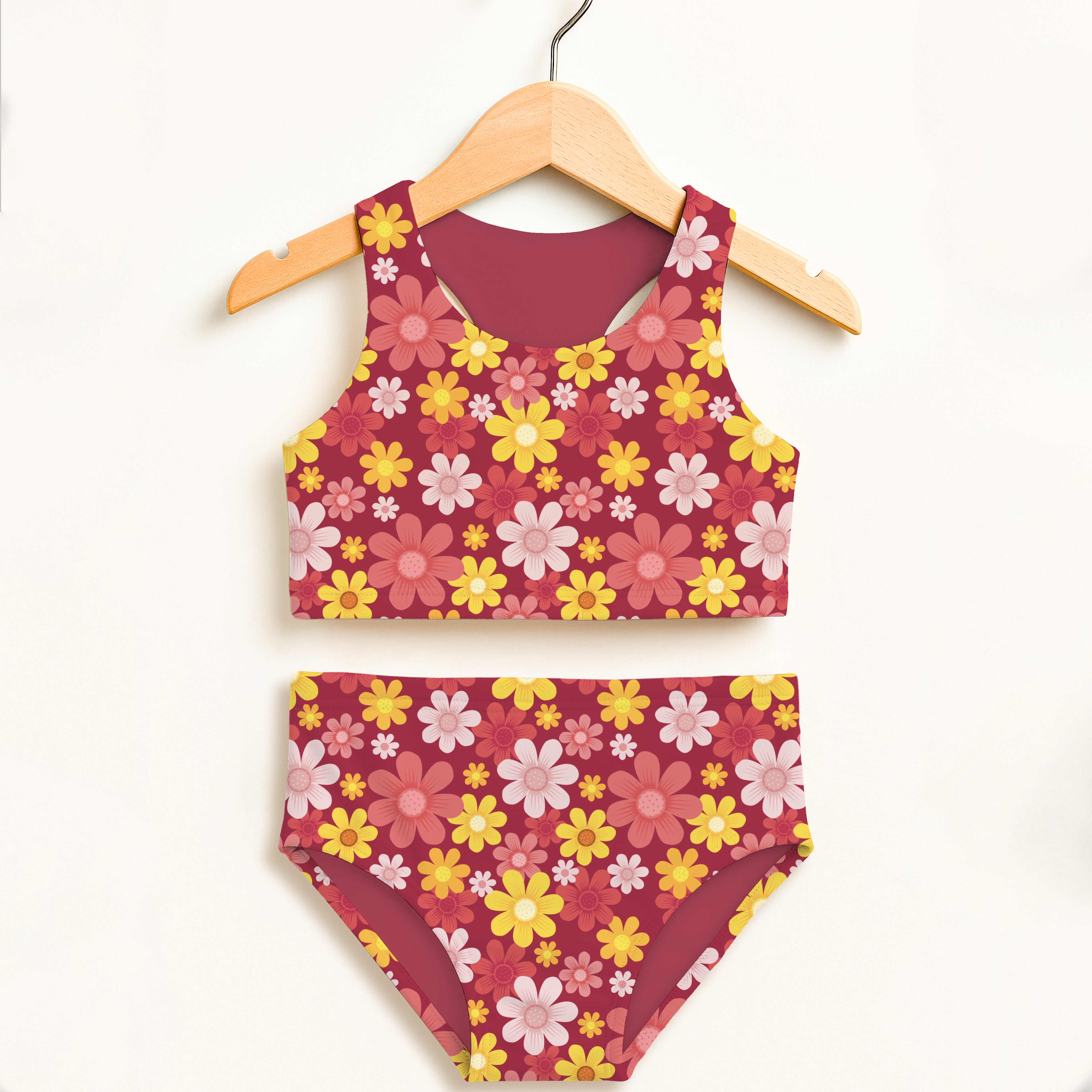 A girls red floral two piece swimsuit with a maroon base and yellow pink white daisy patterns upf 50 plus high waisted comfort