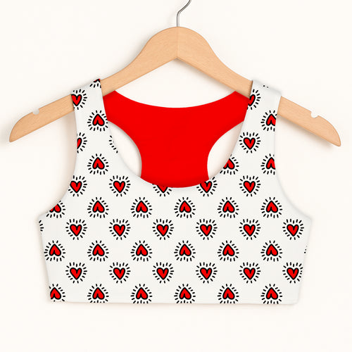 Girls doodle heart sports bra in white with red hearts and black outlines featuring quick drying double layered comfort