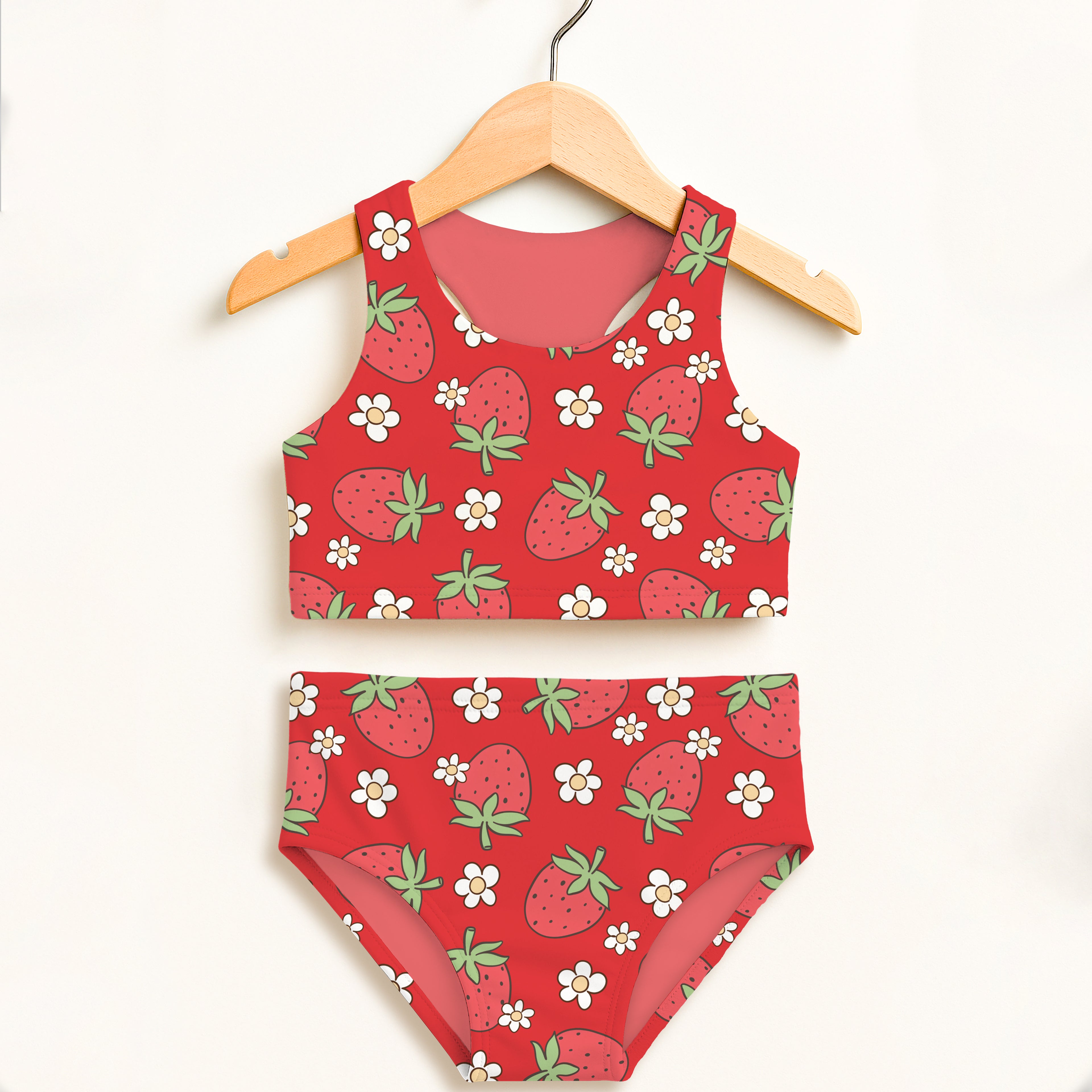 Girls red strawberry two piece swimsuit with white flower pattern hanging on wooden hanger double layered upf 50+