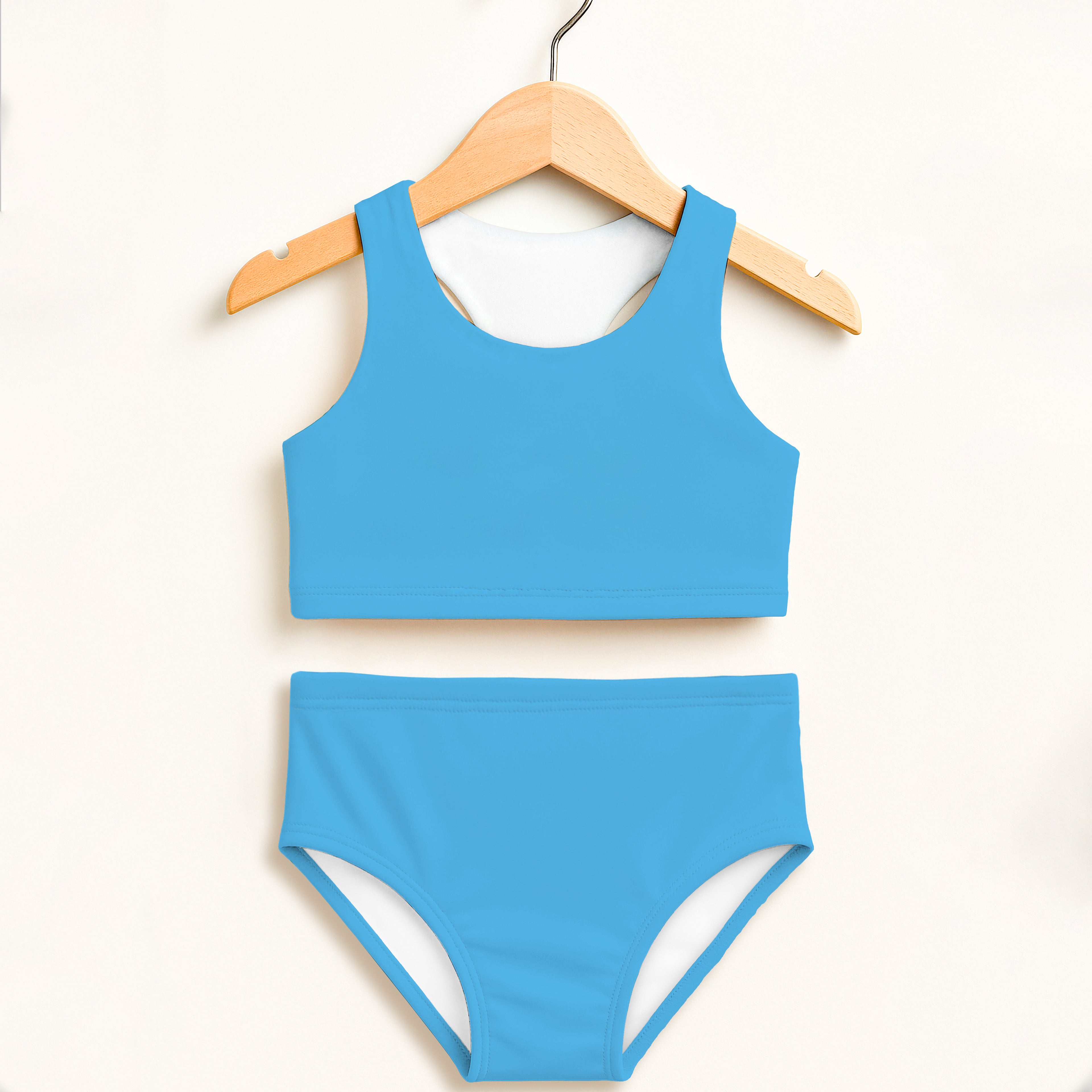 Girls sky blue two piece swimsuit with white lining hanging on wooden hanger featuring double layered upf 50+ fabric