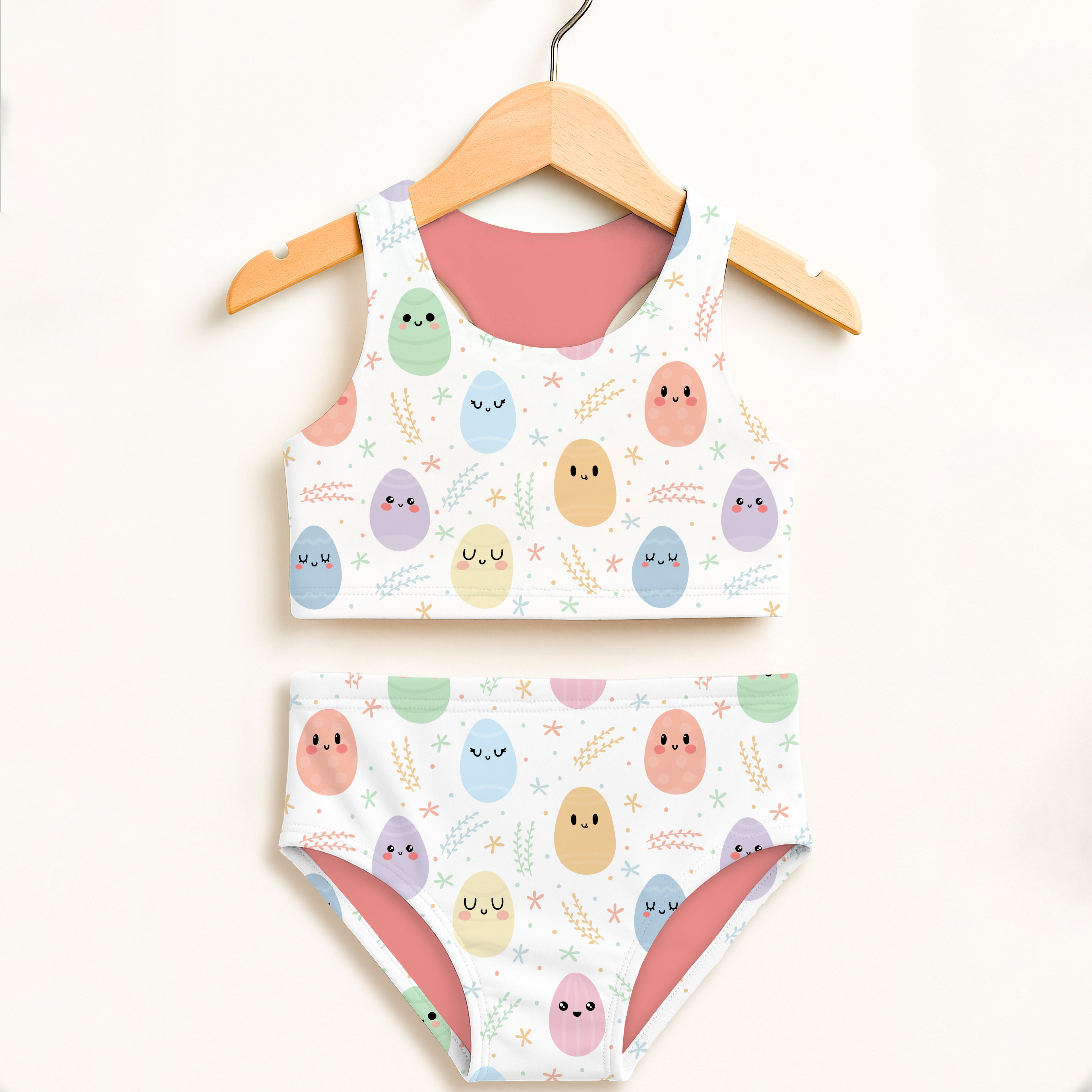Girls smiling Easter egg two piece swimsuit with pastel colors white base pink lining and UPF 50 plus high waisted comfort