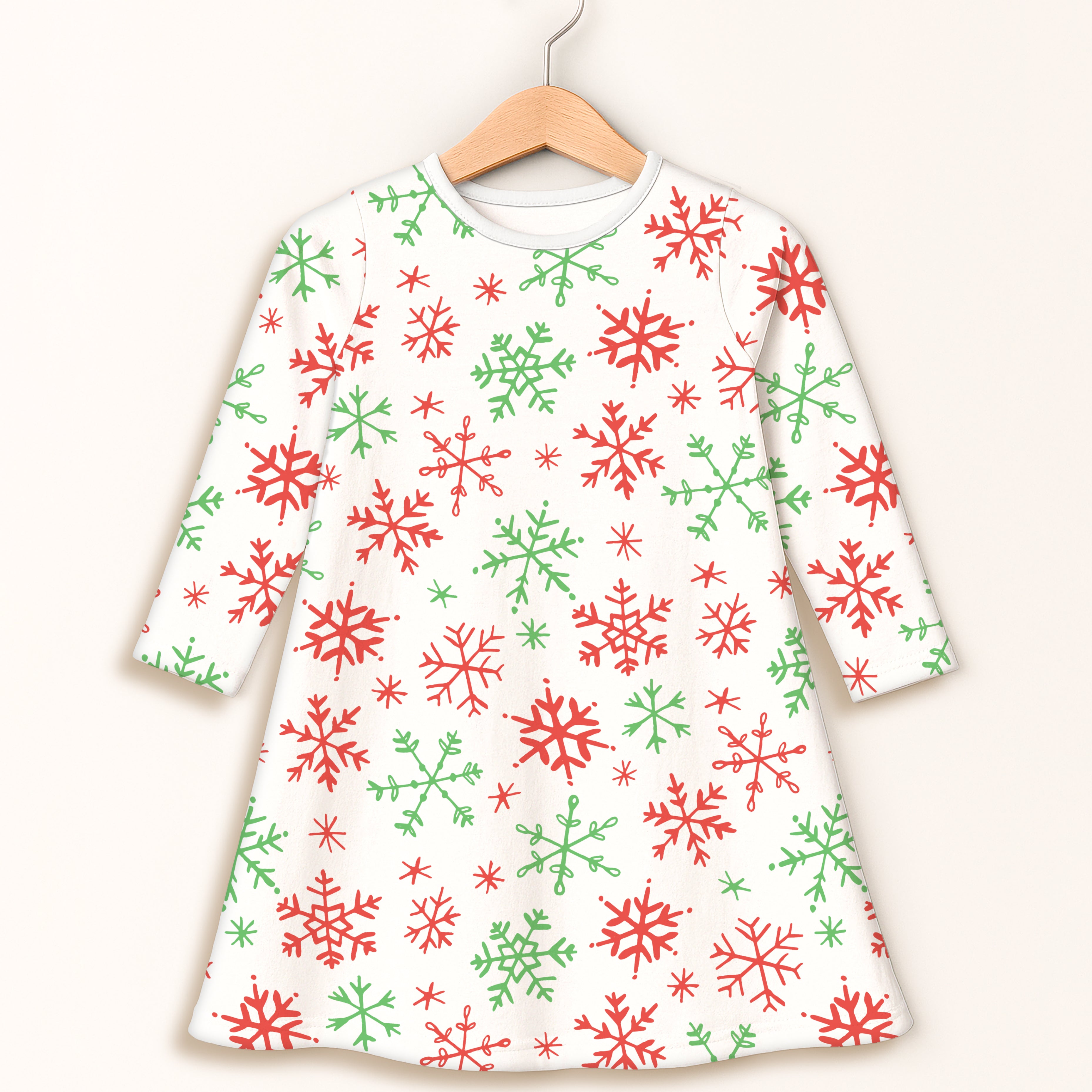A white girls long sleeve dress with red and green snowflake pattern for festive occasions