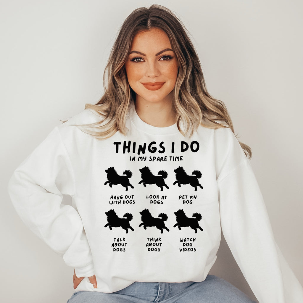 Woman wearing a white sweatshirt with black text and dog illustrations on a plain background
