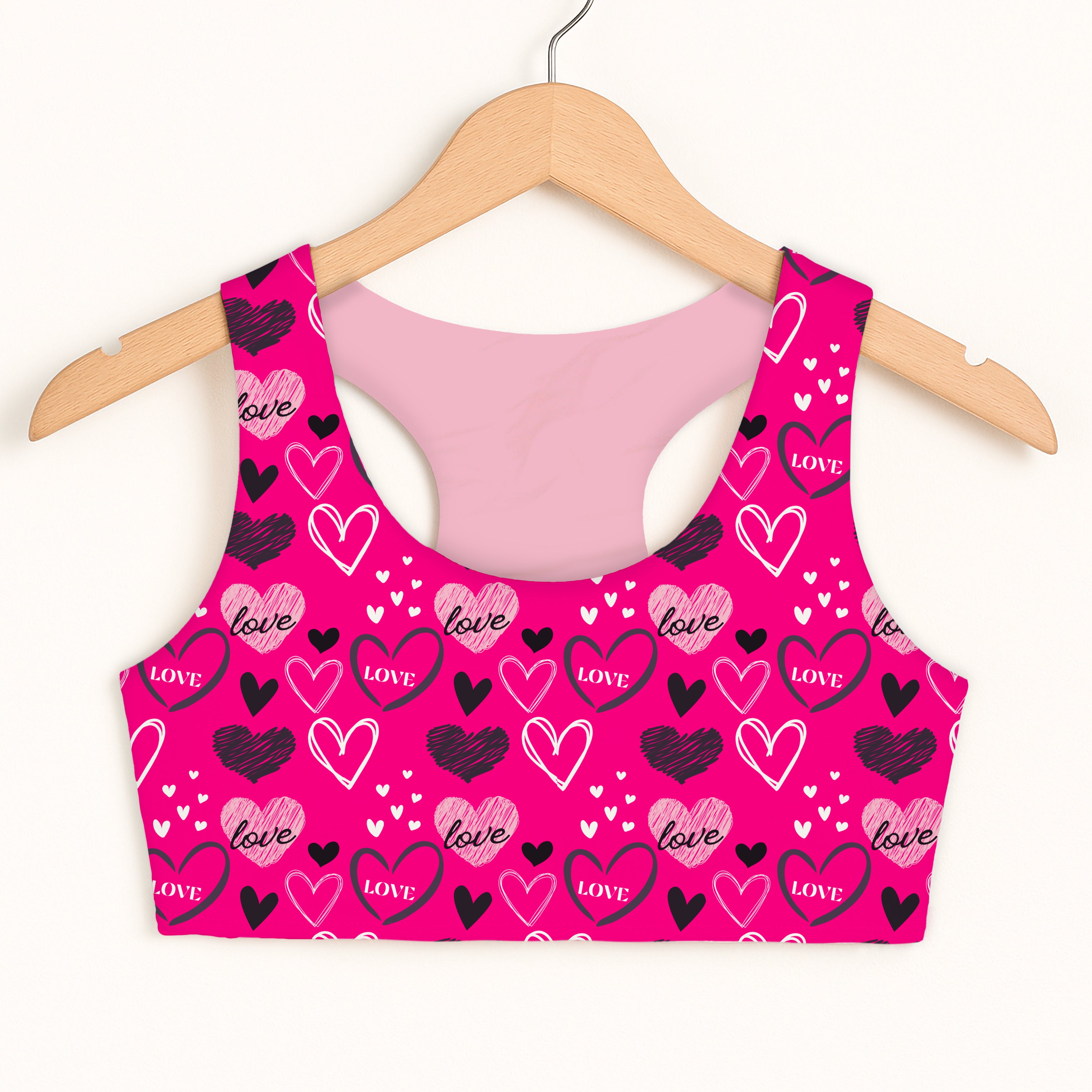 A vibrant pink girls Valentine’s Day love heart sports bra with quick-drying fabric and double-layered comfort