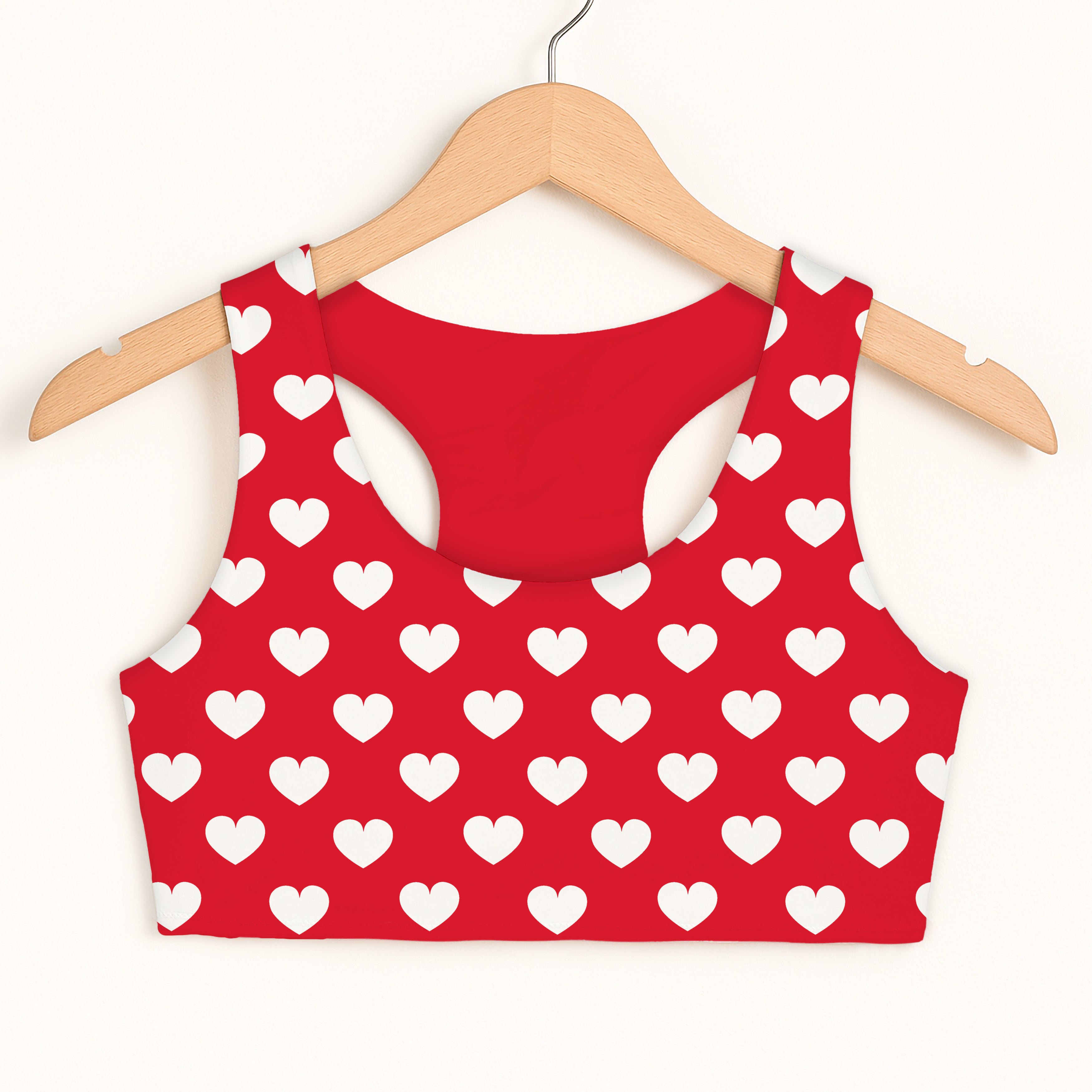 Girls red heart sports bra with quick drying fabric and double layered comfort hanging on a wooden hanger