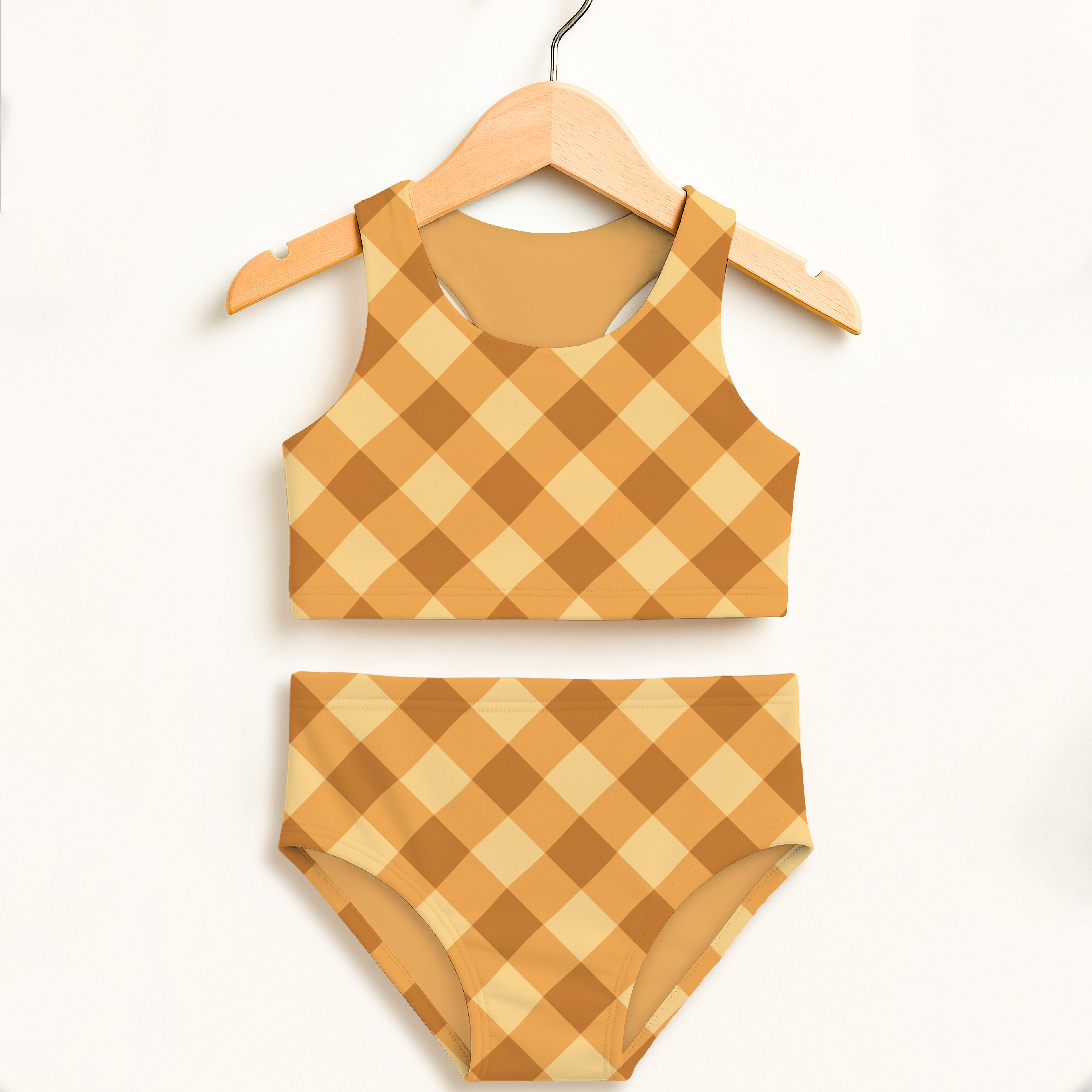 Girls mustard gingham two piece swimsuit with tan and beige checkered pattern on wooden hanger with upf 50+ protection