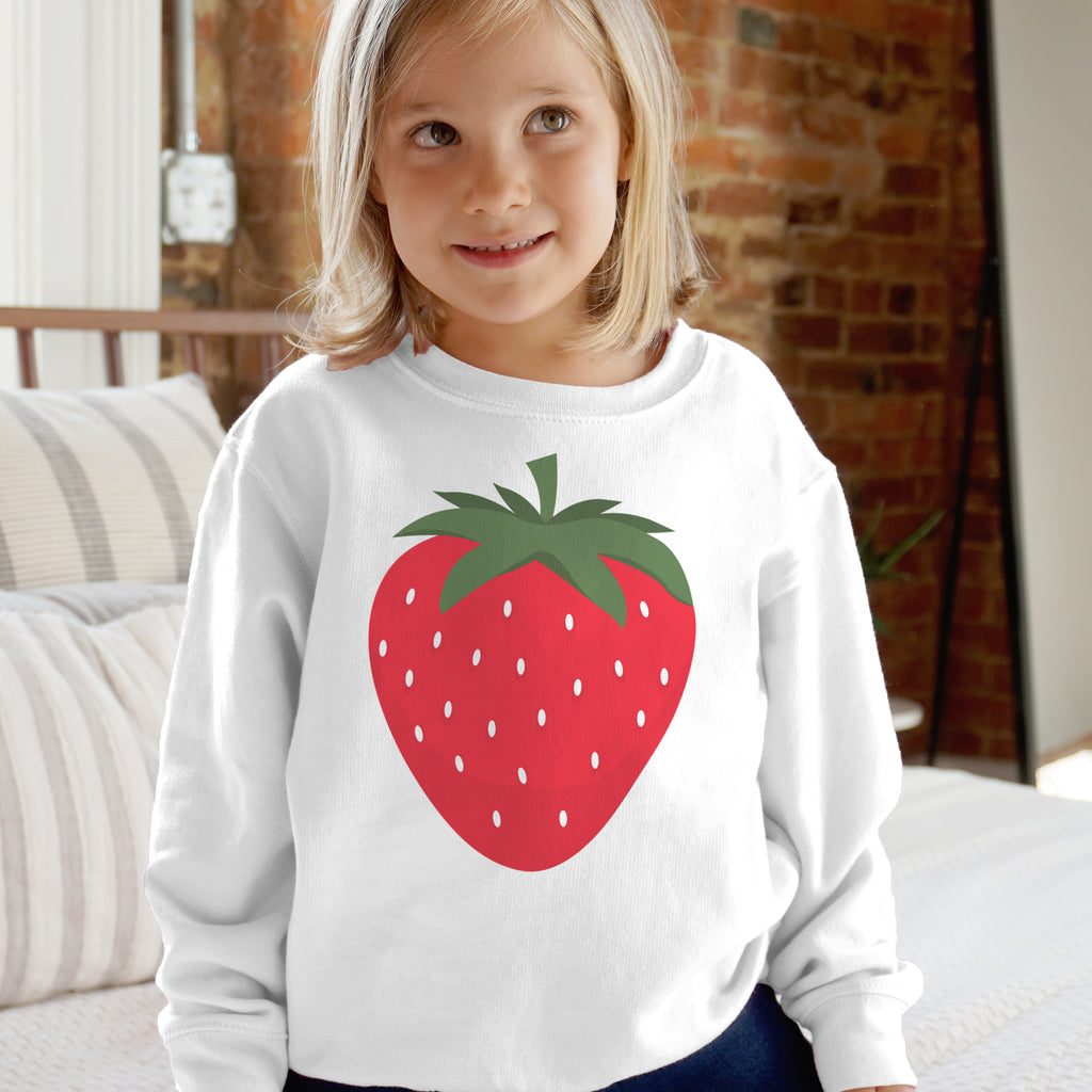 White kids sweatshirt with long sleeves featuring a large red strawberry graphic with green leaves and white seeds