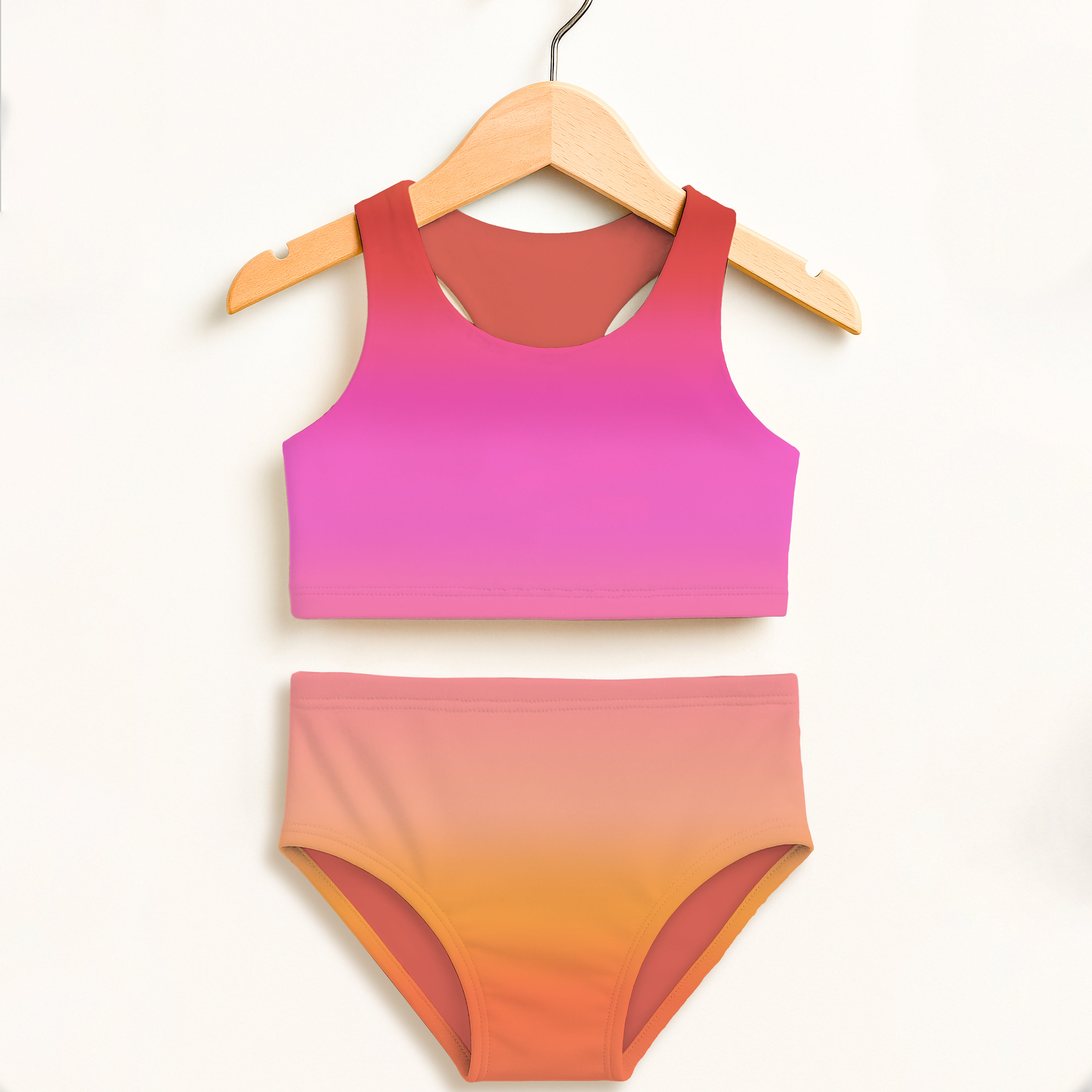 A girls sunset ombre two piece swimsuit in pink to orange gradient made from smooth stretchy fabric with upf 50+ protection