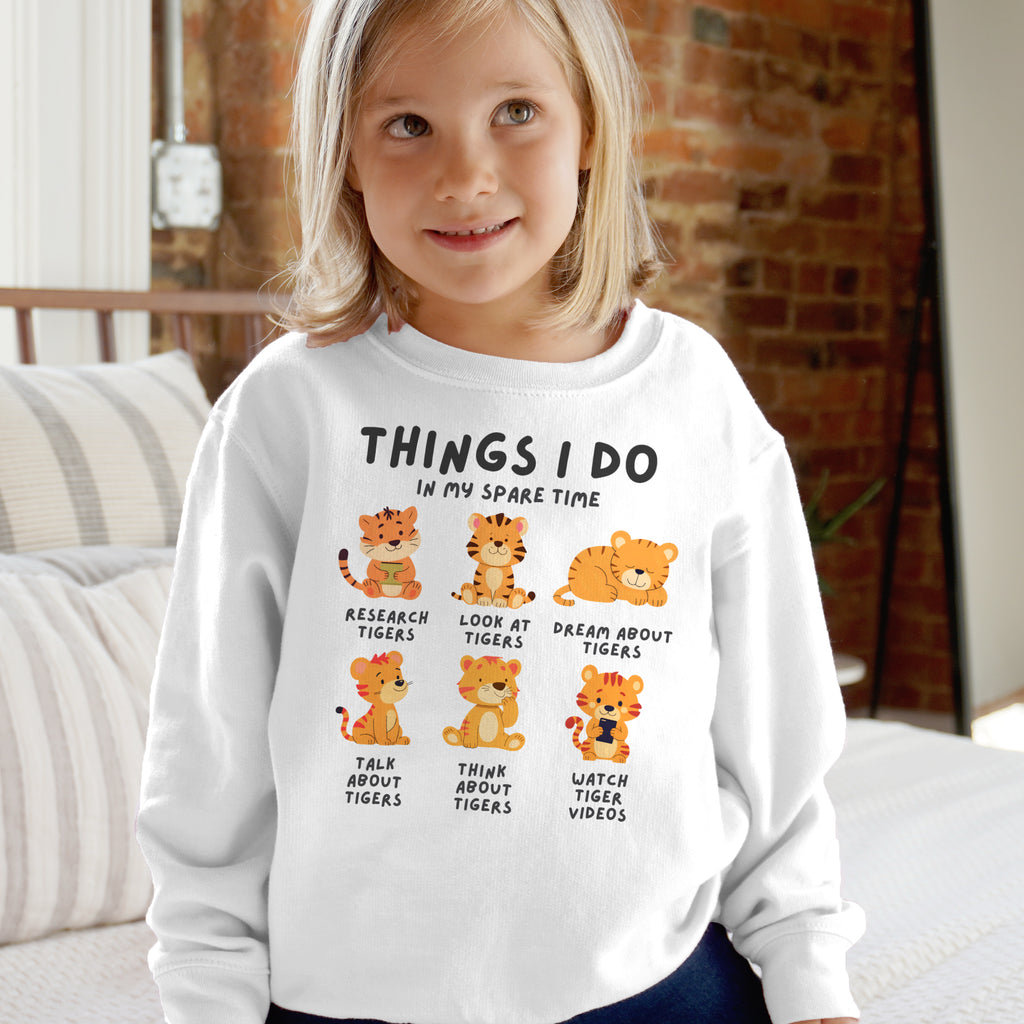 Child wearing a white sweatshirt with tiger-themed text and graphics