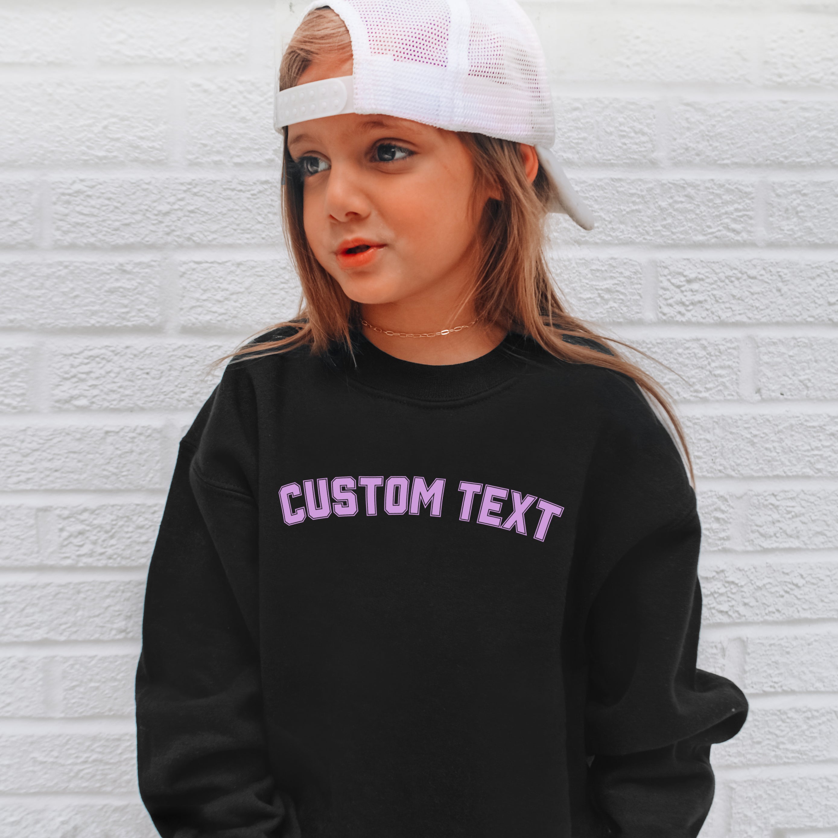 Black sweatshirt with purple arched varsity text personalized with custom kids name on front chest
