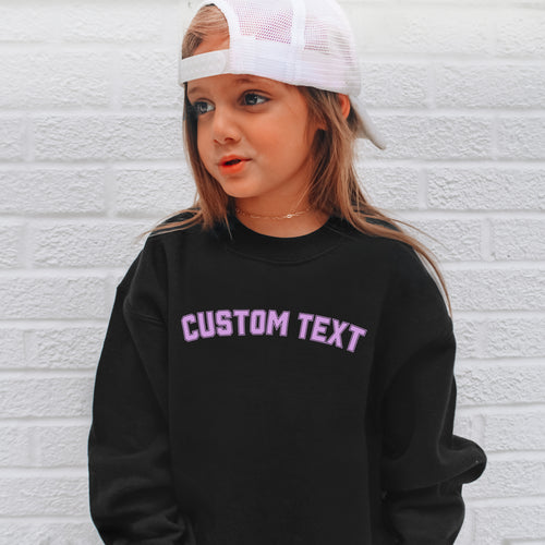 Black sweatshirt with purple arched varsity text personalized with custom kids name on front chest