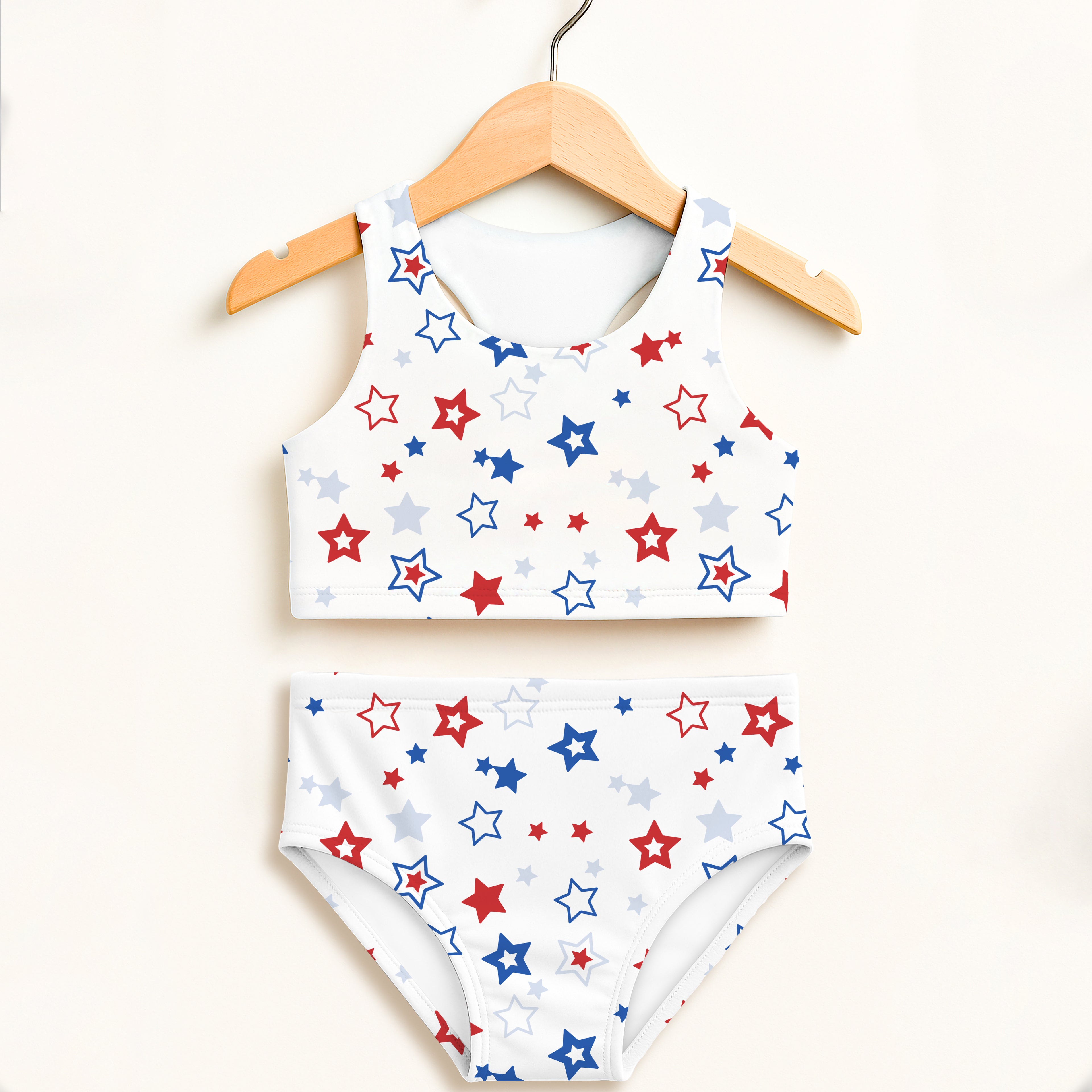 White girls two piece swimsuit with halter top and high waisted bottoms featuring red blue and silver stars pattern