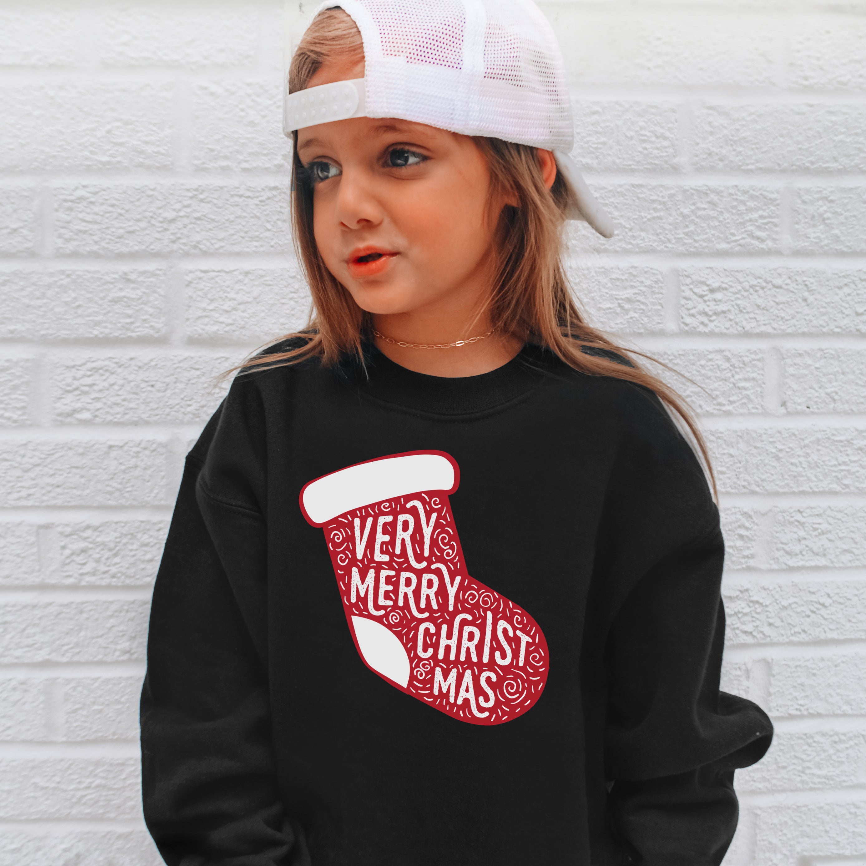 Kids very merry christmas sweatshirt black long-sleeved pullover with red stocking graphic and white text design